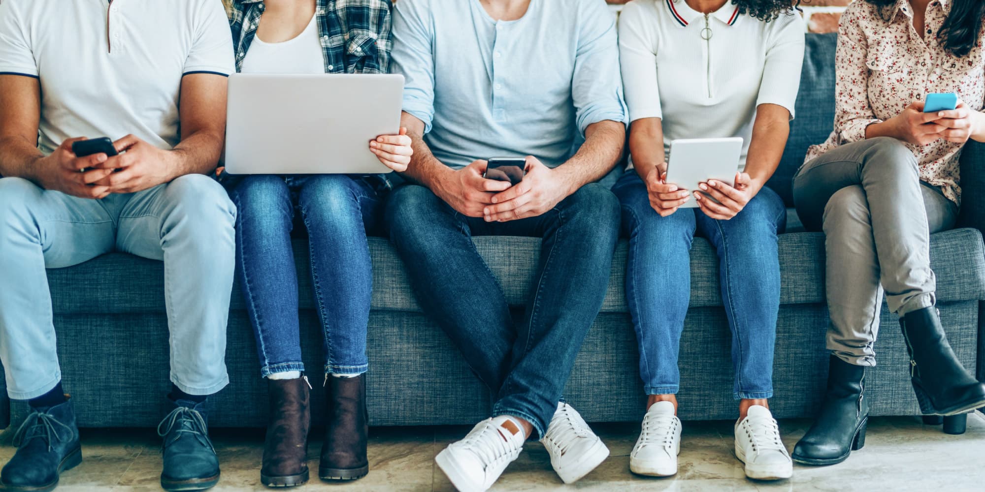 digimeter Meerdere mensen zitten op een bank met laptops en smartphones