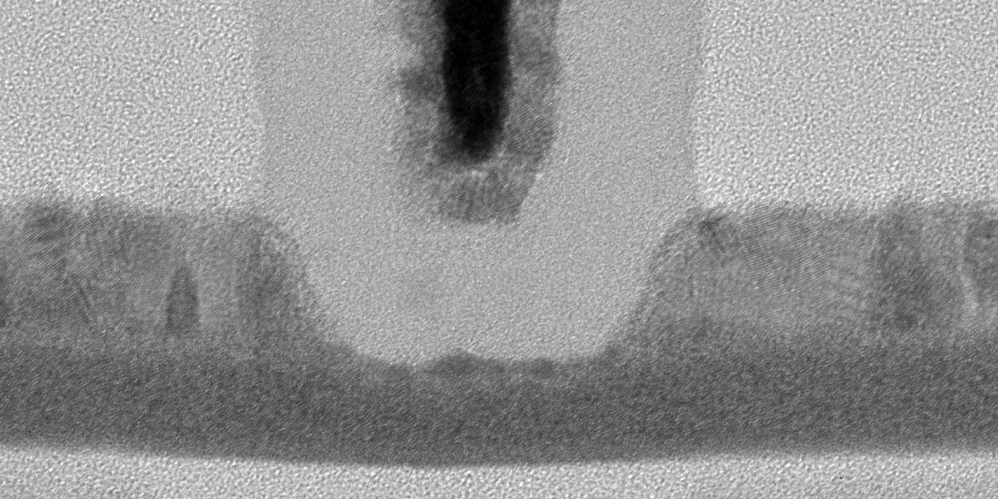 DRAM-cell Microscope close-up of a semiconductor device cross-section with layered materials and a central contact