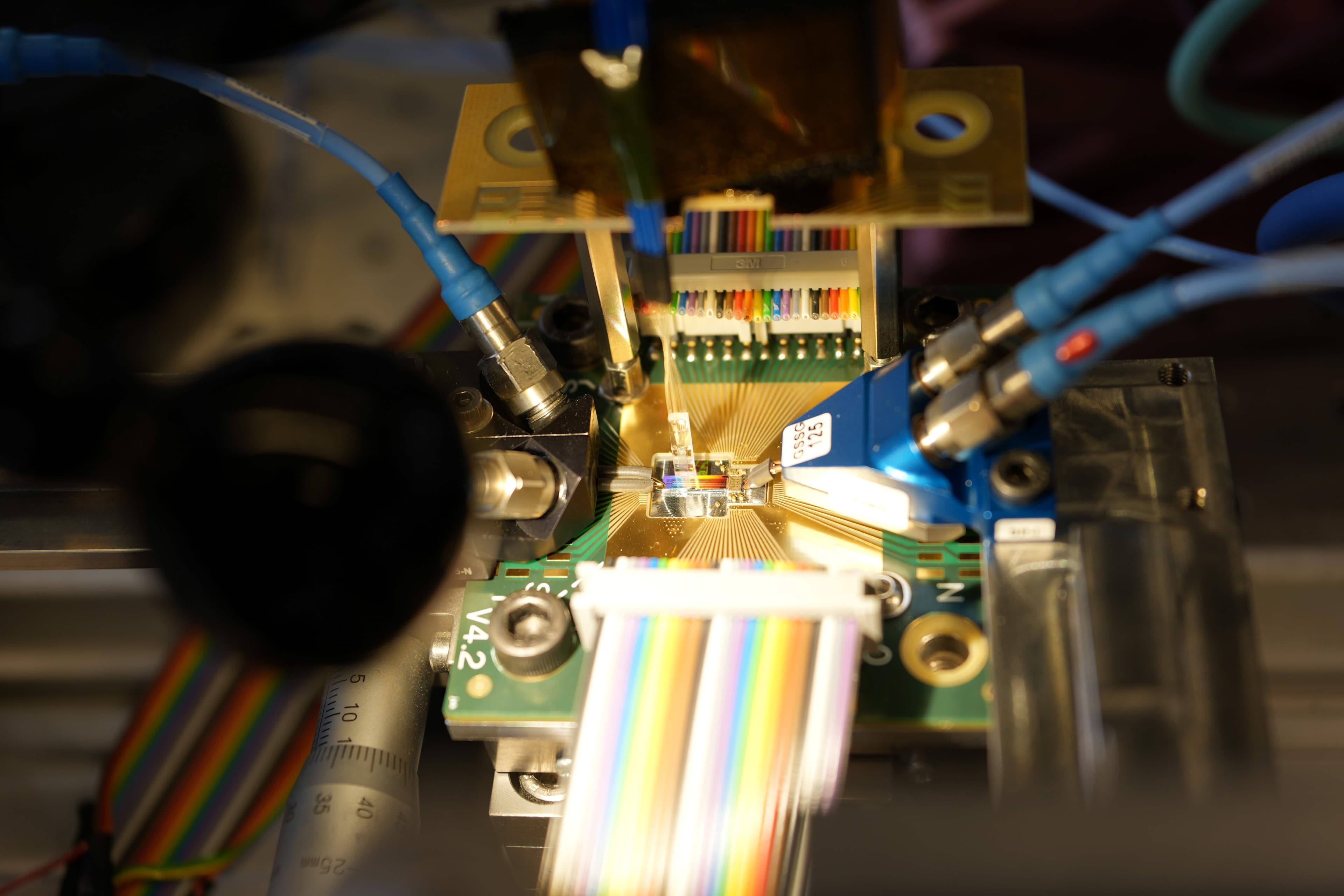 optical lab setup with fiber cables and photonic chip Optical lab setup with fiber cables and connectors aligned to a photonic chip device