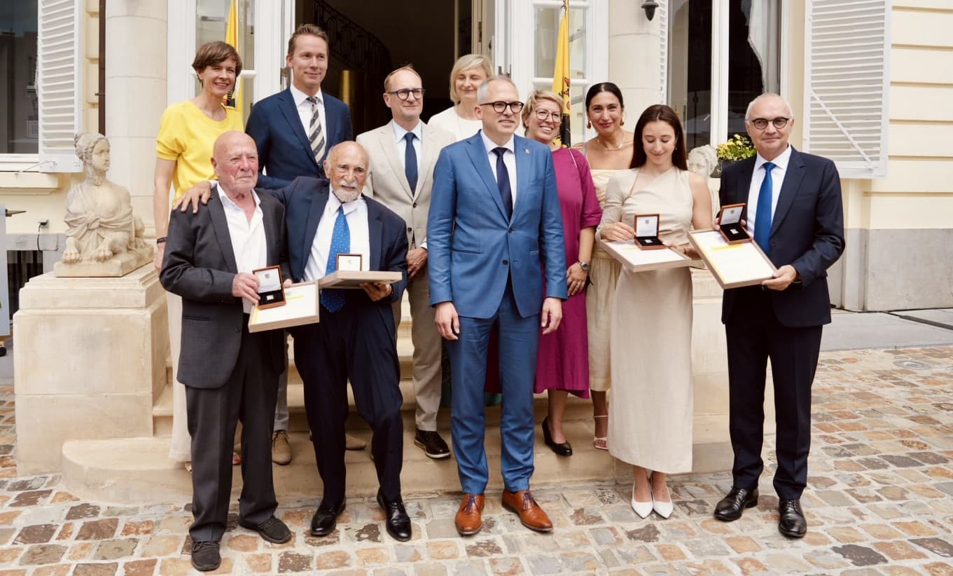 DSC06089 Groep mensen die poseren buiten een formeel gebouw, met prijzen en certificaten