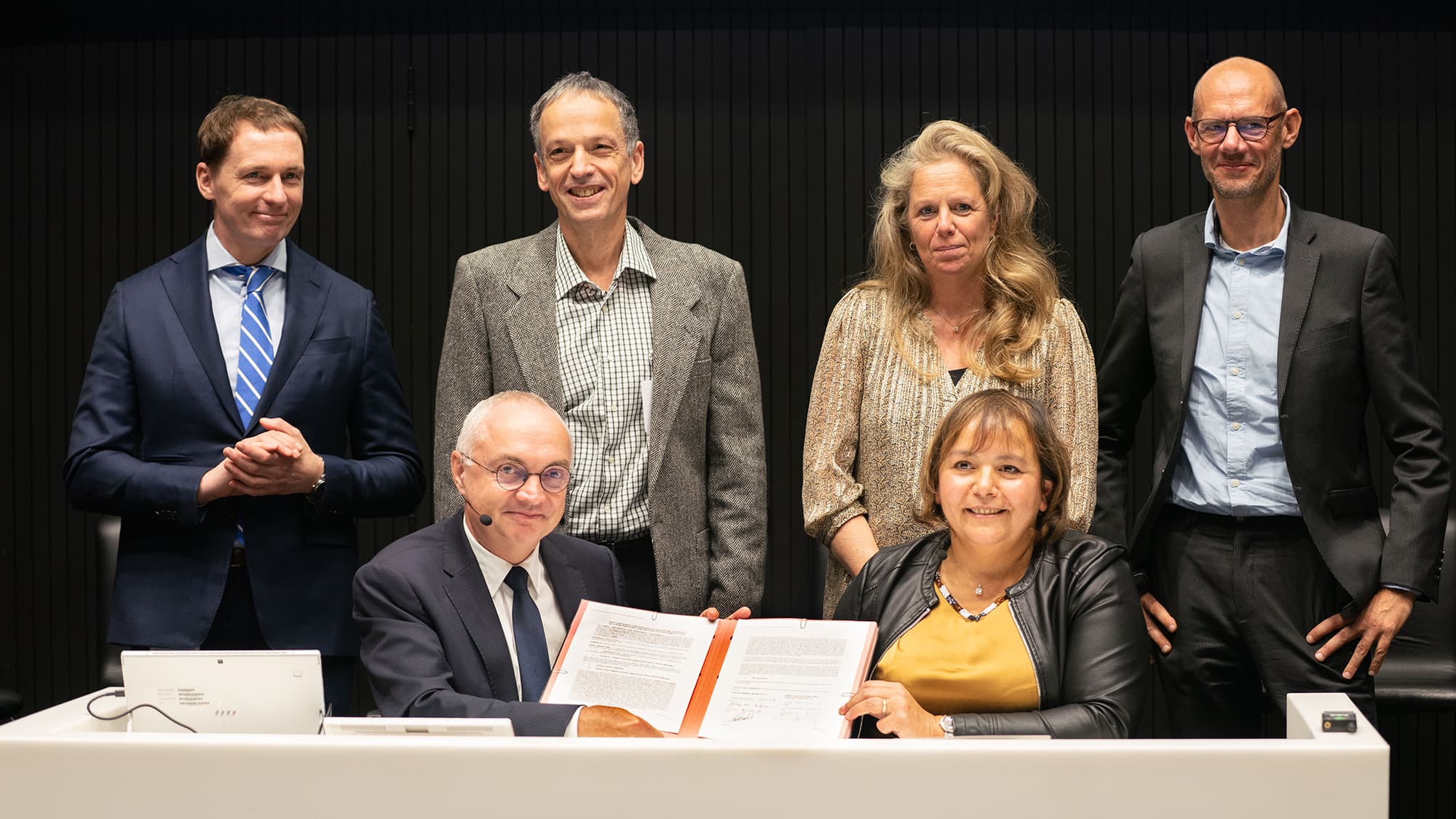 DSC08849 GSK and imec representatives pose with a signed collaboration agreement at a conference table