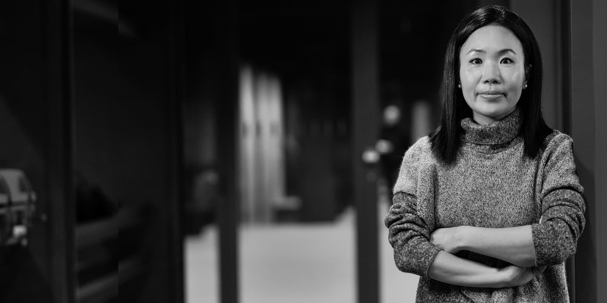 E.Park001magazinenew_1 Portrait of Jung Yeon Park standing with arms crossed in a hallway, black and white.