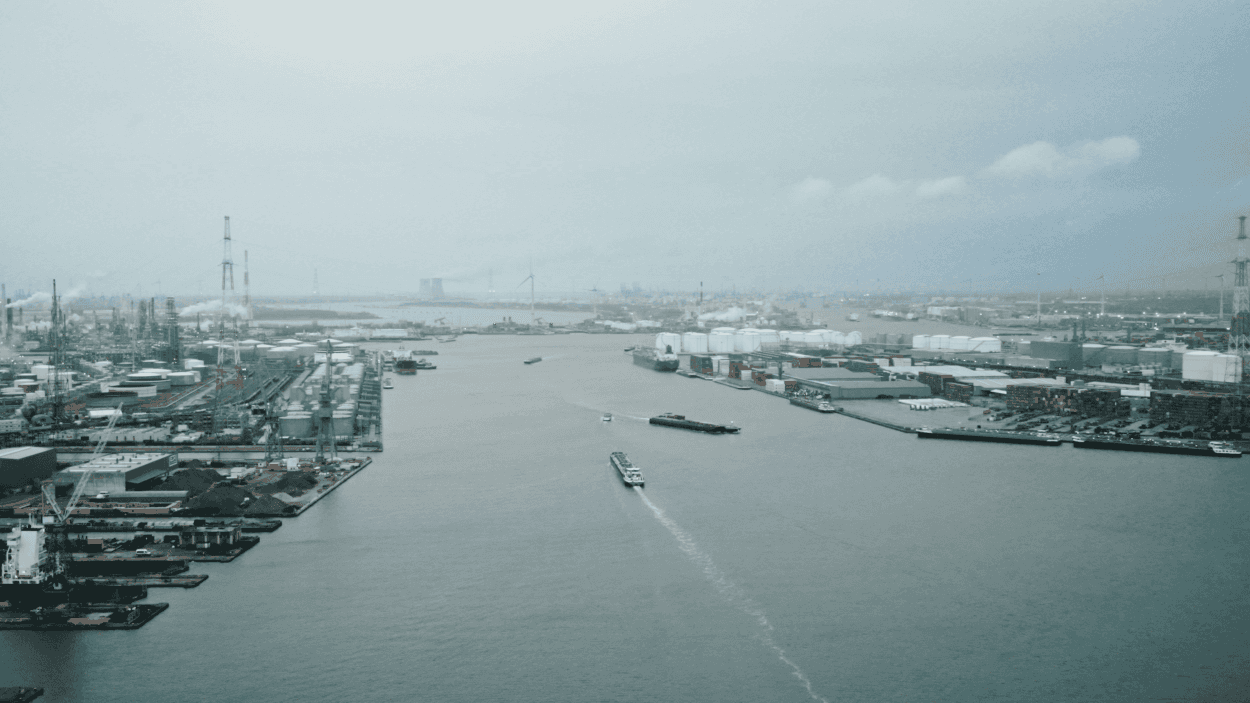 EdgeApp_Header%20Image%20%28Compressed%29 Wide view of an industrial harbor with ships, cranes, and factories along a canal under cloudy skies