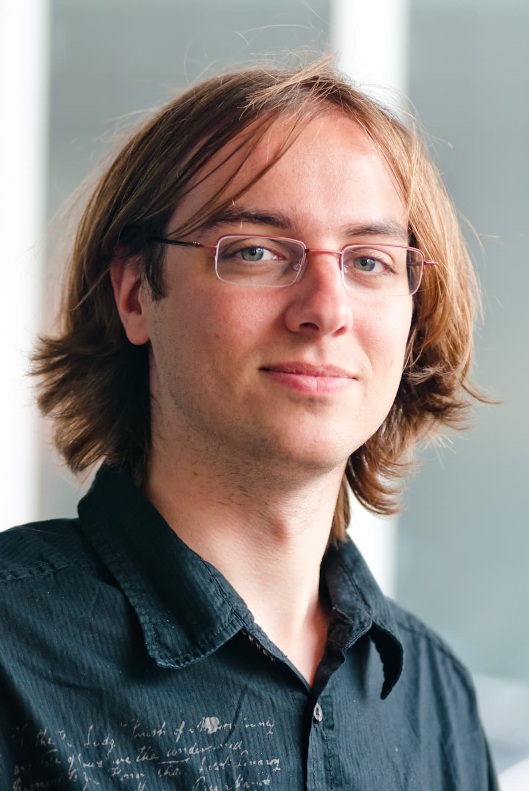 Eli_Depoorter_1 Portrait of Eli De Poorter wearing glasses and a dark shirt.