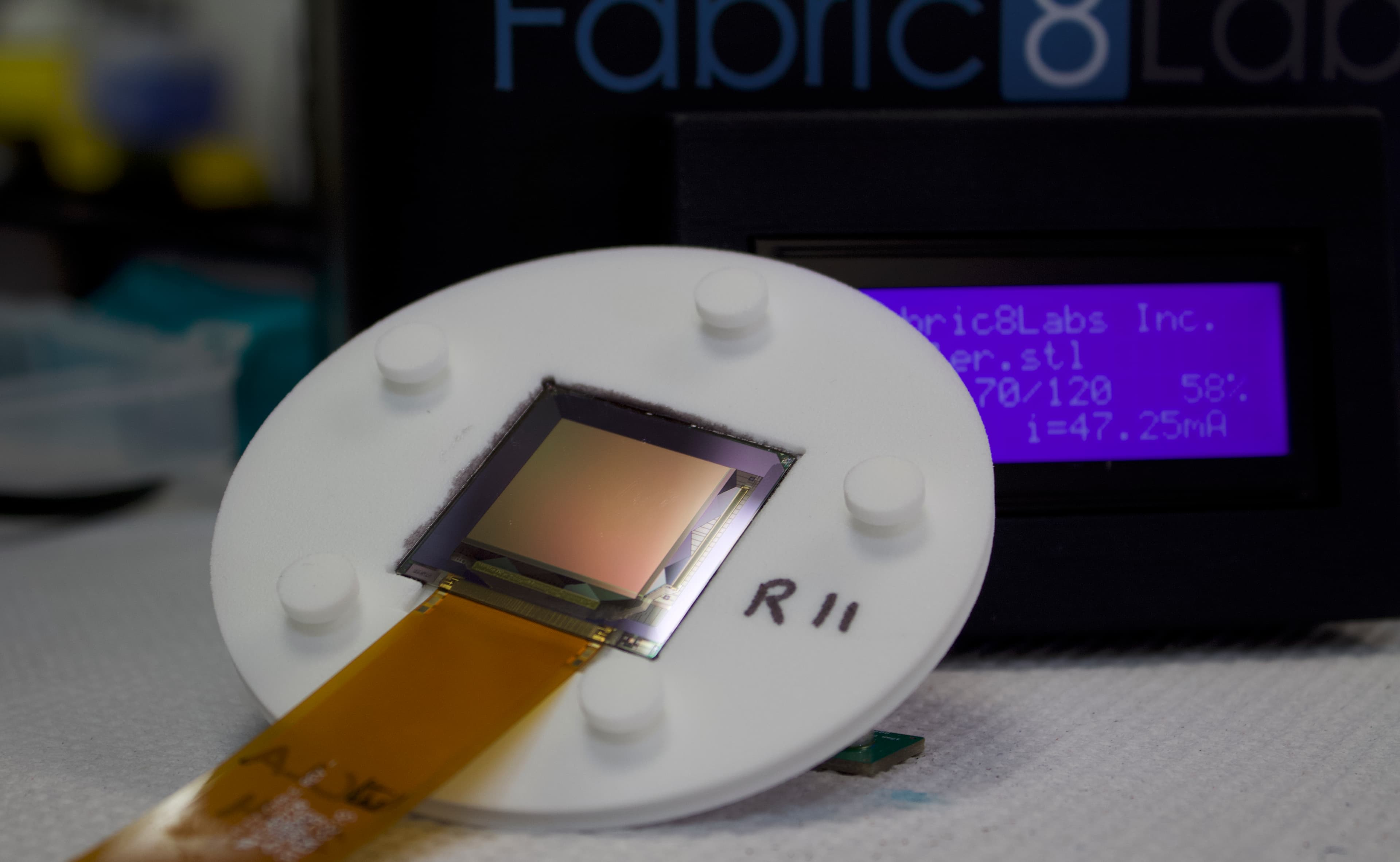 Fabric8Labs%2520-%2520TFT%2520Print%2520Head_2 Printkop met een micro-elektrode-array en een siliciumchip in een laboratoriumopstelling