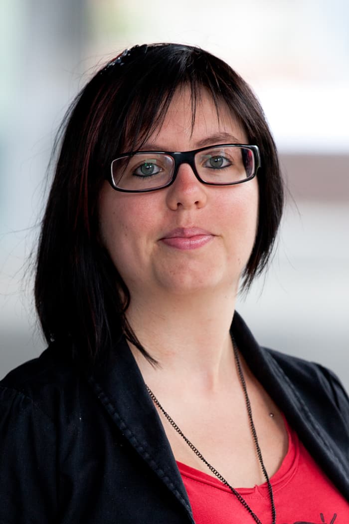 Femke-Ongenae_0 Portret van Femke Ongenae met een bril en een zwart colbert