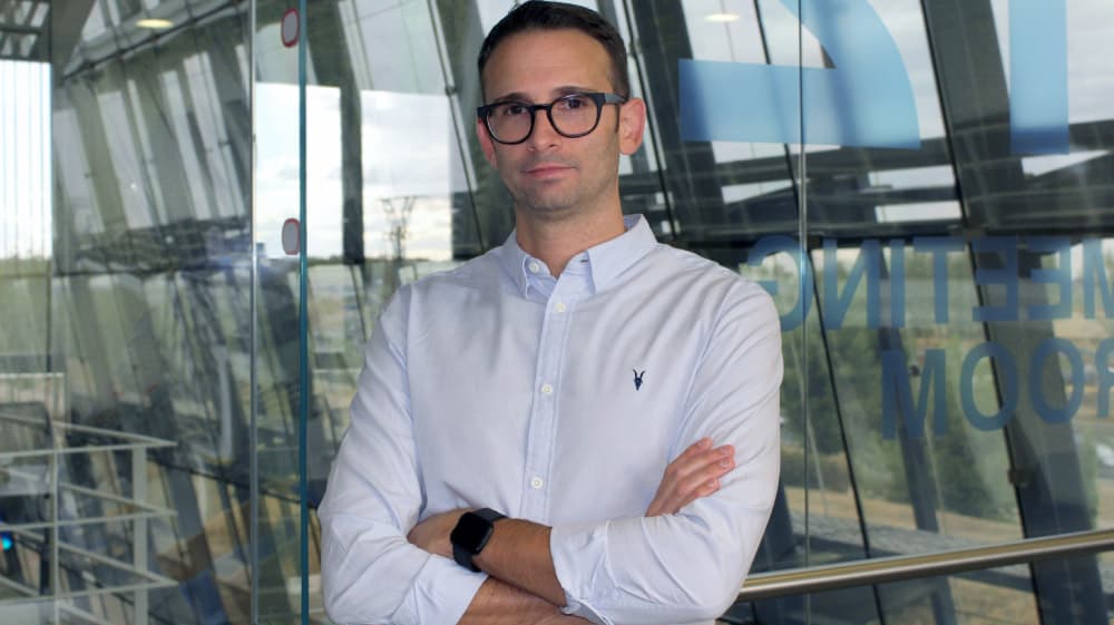 ferrran-tejada Ferran Tejada standing with arms crossed in a glass-walled office