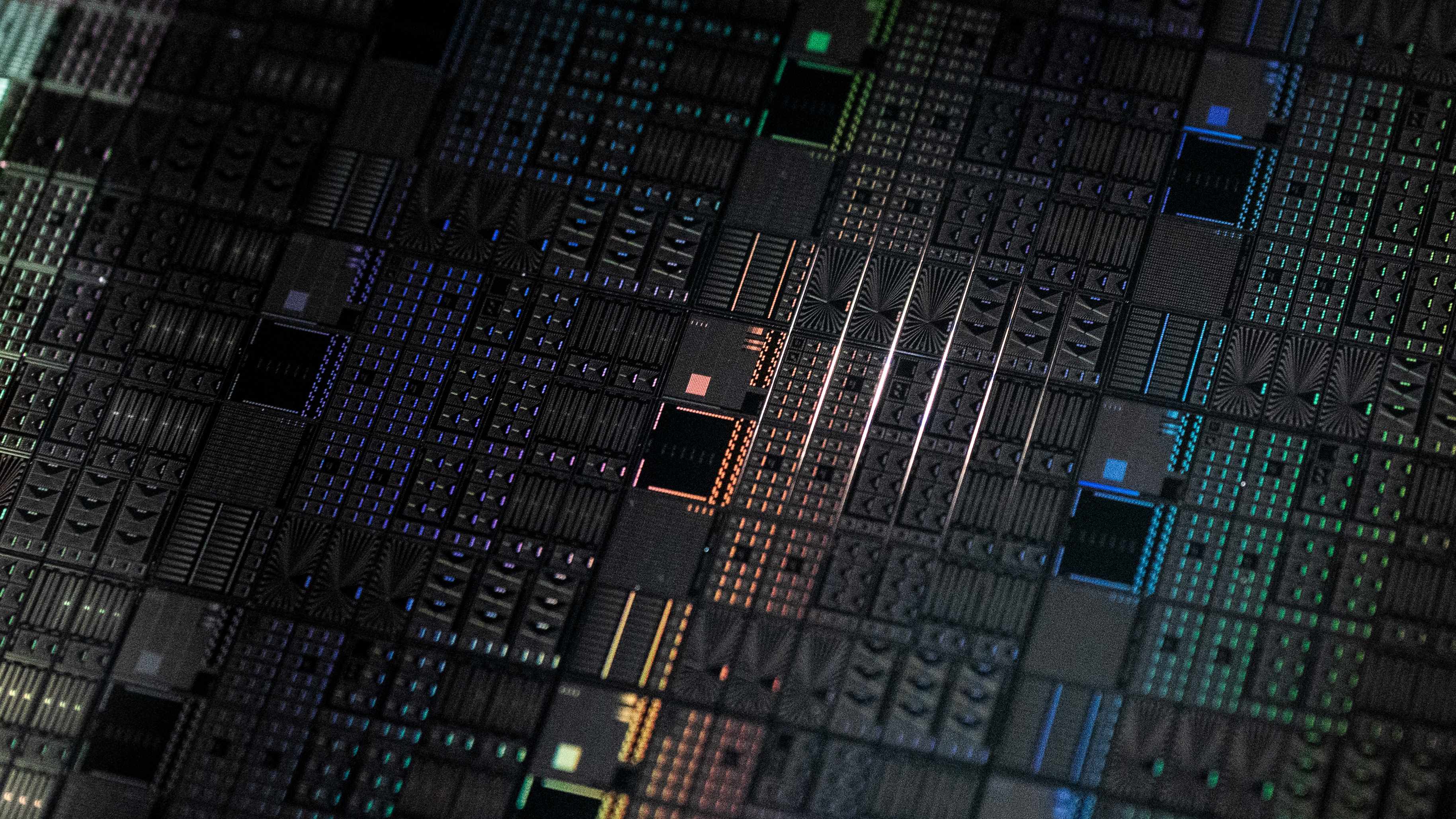 Close-up of patterned silicon quantum chip die Close-up of a patterned quantum chip die with multicolored circuit features on a dark wafer