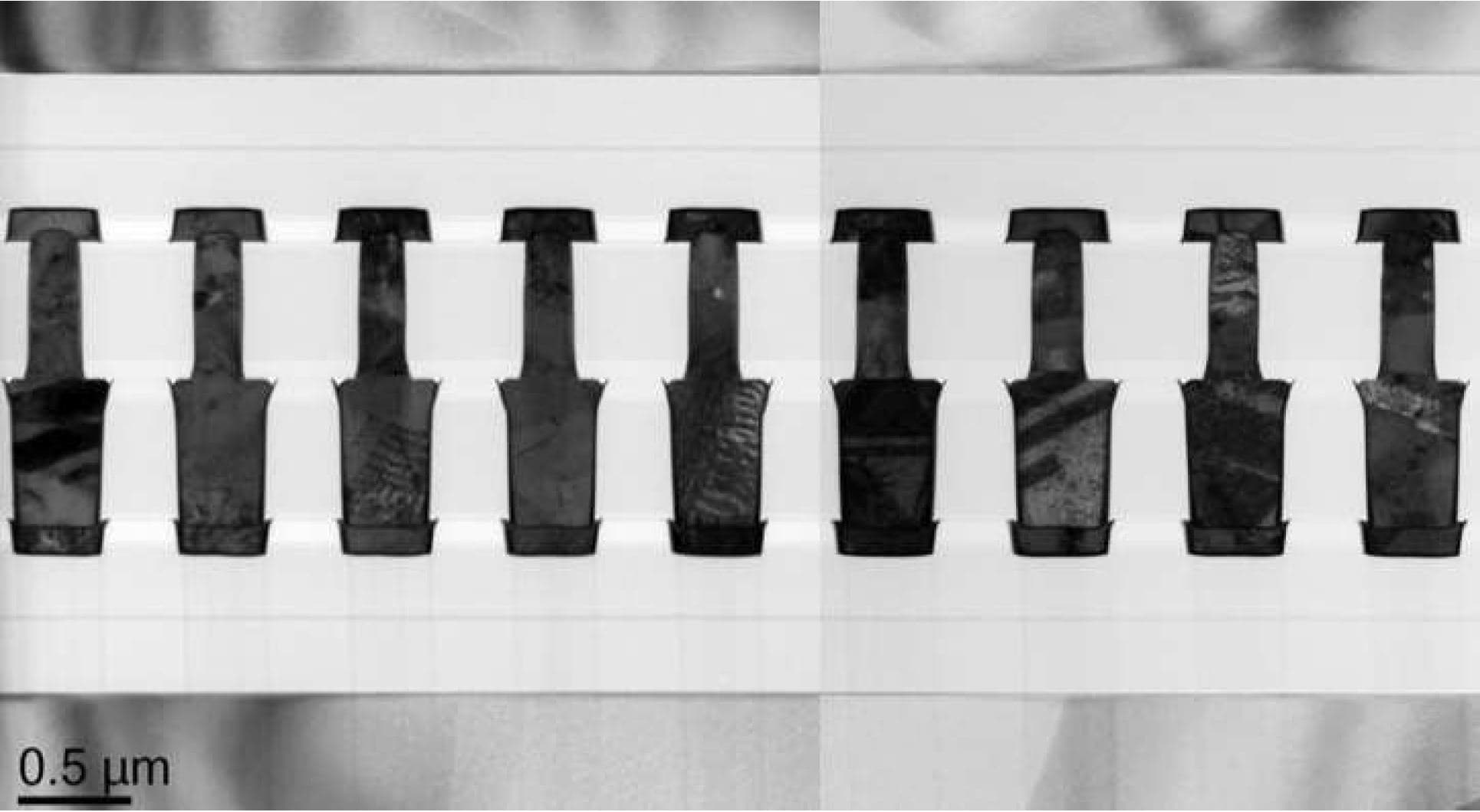 Figure%202%20-%20W2W%20bonding Microscope cross-section of wafer-to-wafer hybrid bonding with aligned interconnects and 0.5 µm scale bar.