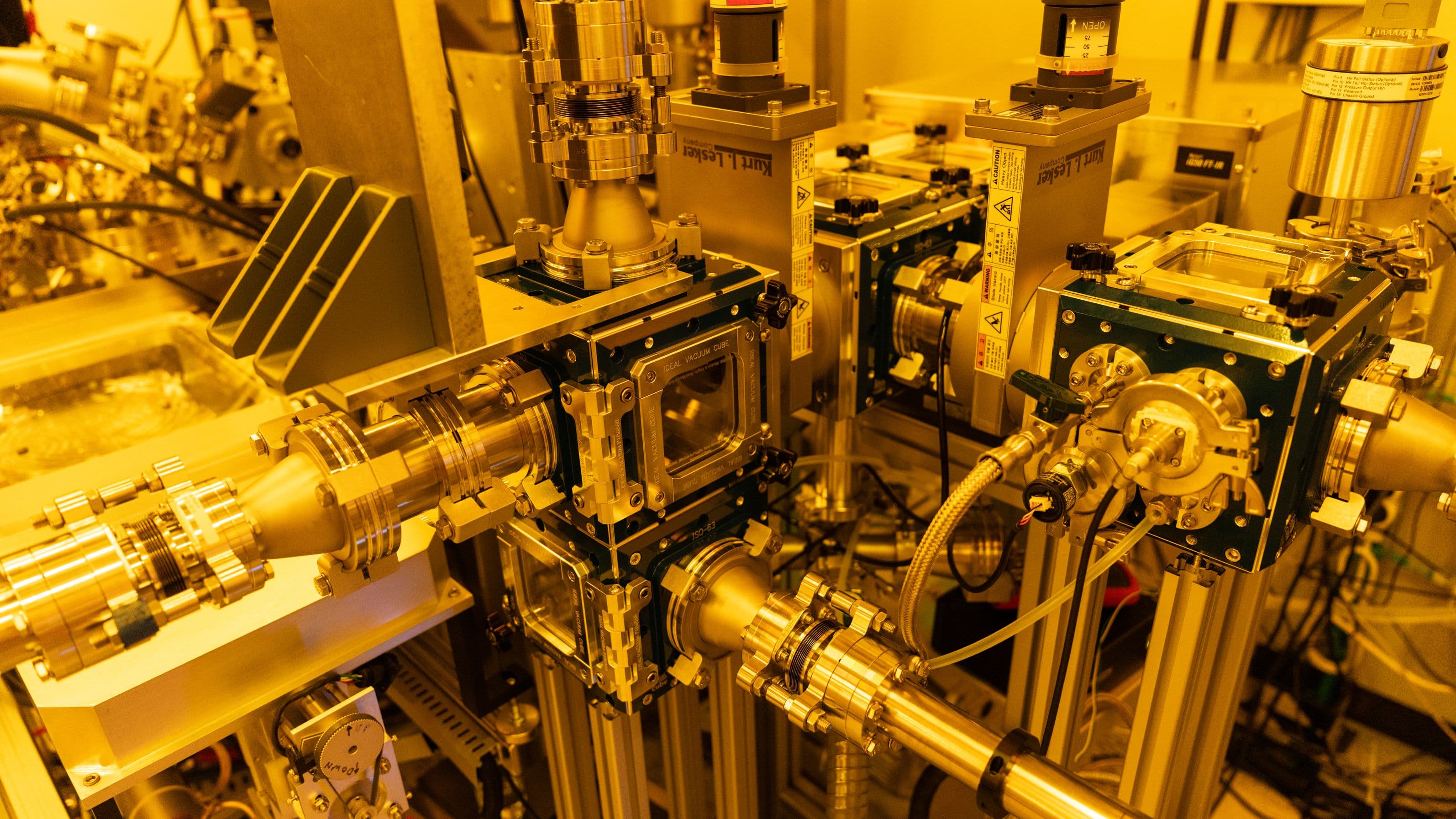 BEFORCE lithography tool in cleanroom BEFORCE lithography tool with vacuum chambers and metal tubing in a yellow cleanroom setting