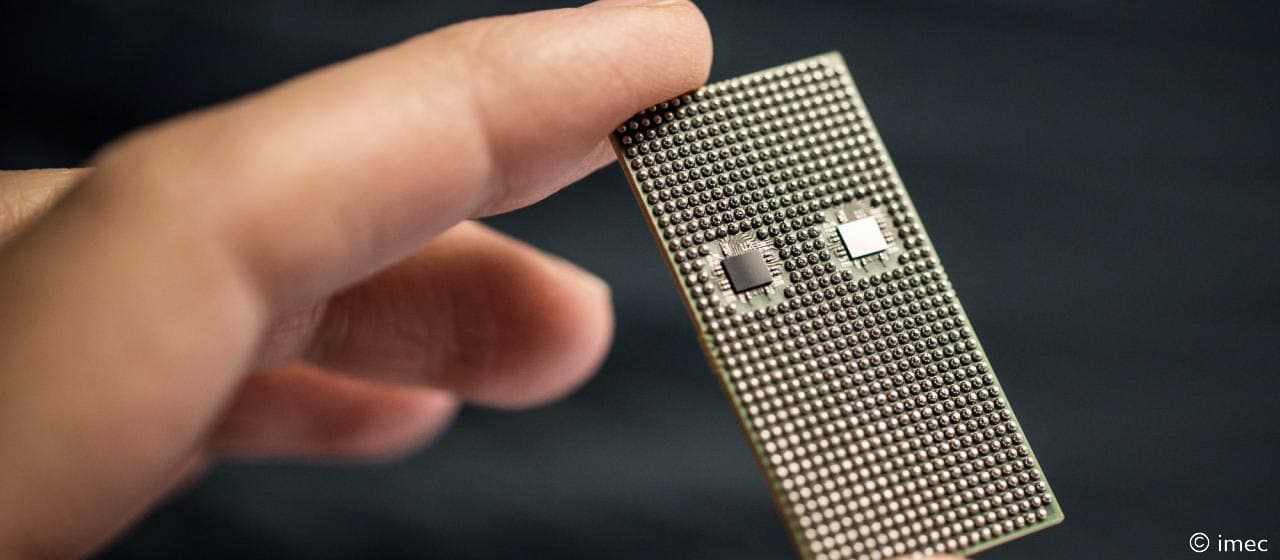 Figuur%205_imec%2079GHz%20radar%20chip Hand houdt een radarsensorchip vast met twee kleine componenten op de behuizing