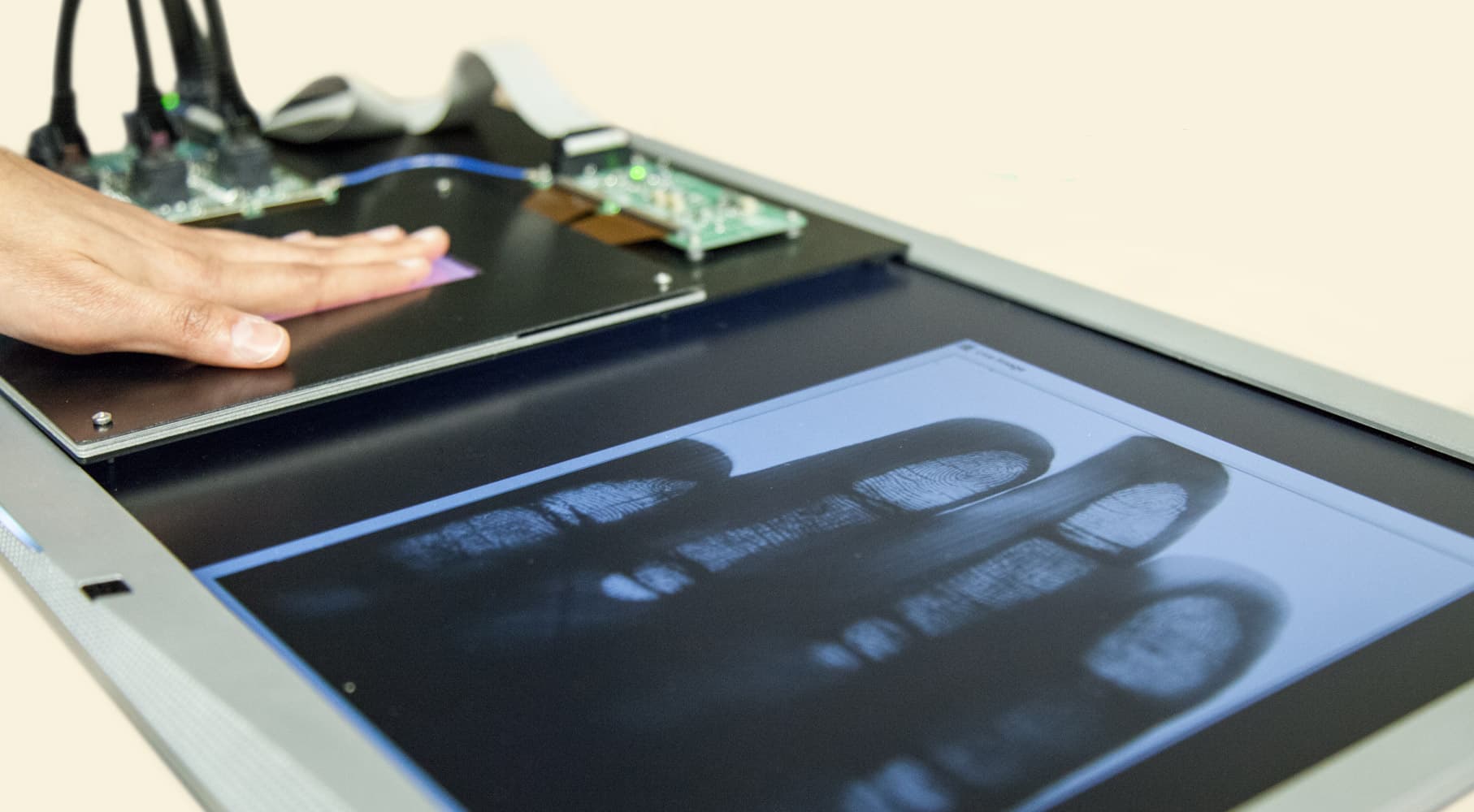Fingerprint-sensor-image-Holst-Centre_1 Hand pressed on a flexible fingerprint sensor, with a fingerprint image displayed on a screen