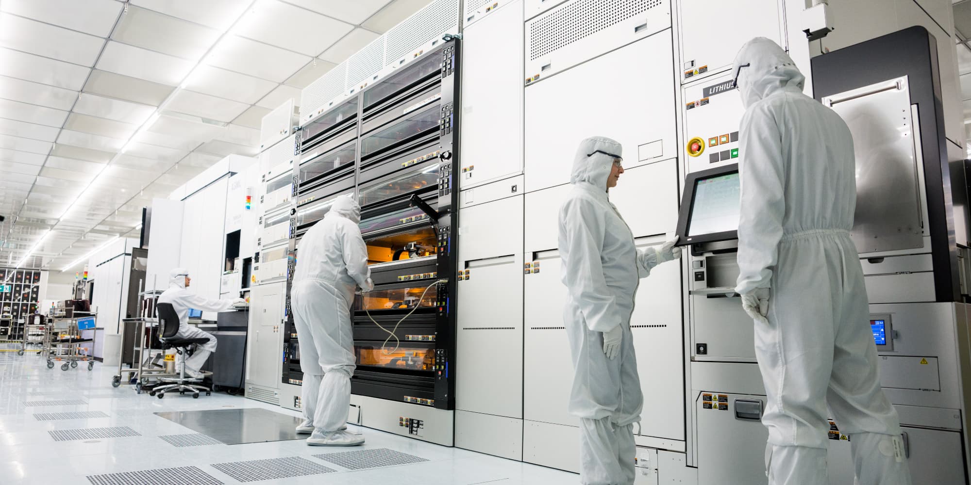 Flat-optics Researchers in cleanroom suits operating semiconductor equipment in a cleanroom
