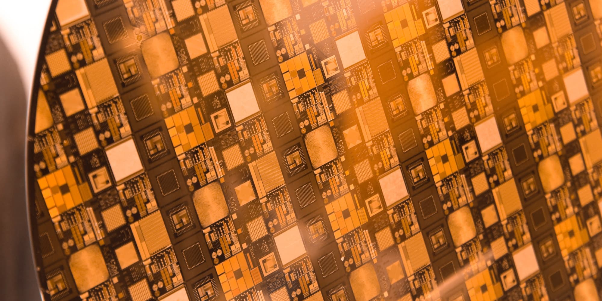 close-up of patterned semiconductor wafer Close-up of a patterned semiconductor wafer with repeated chip structures in orange light