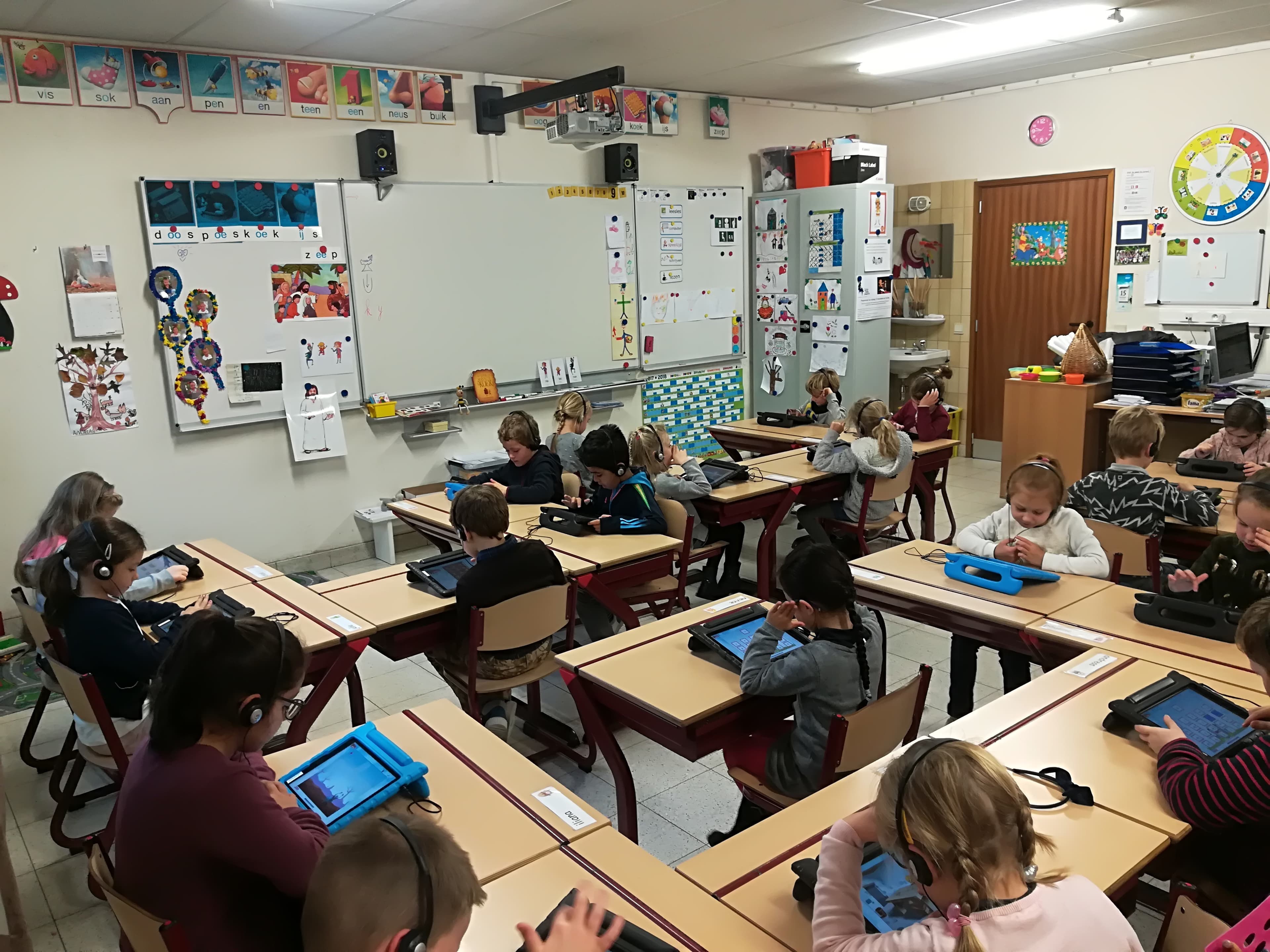 Children in classroom using tablets for learning Children in a classroom using tablets for an adaptive learning game