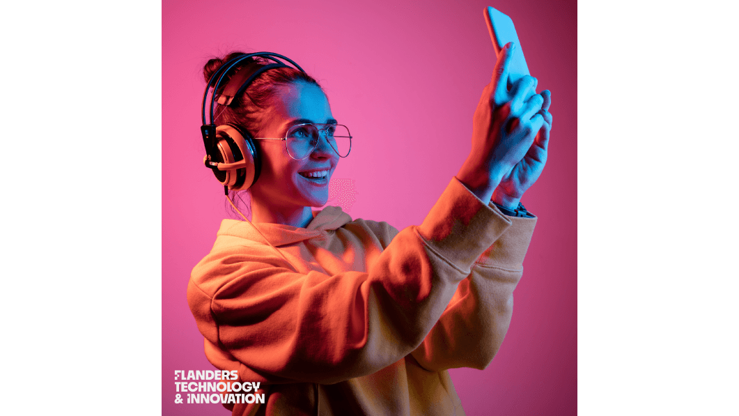 FTI-iets-voor-jou Jonge vrouw met koptelefoon en bril maakt een selfie, met het Flanders Technology & Innovation-logo linksonder.