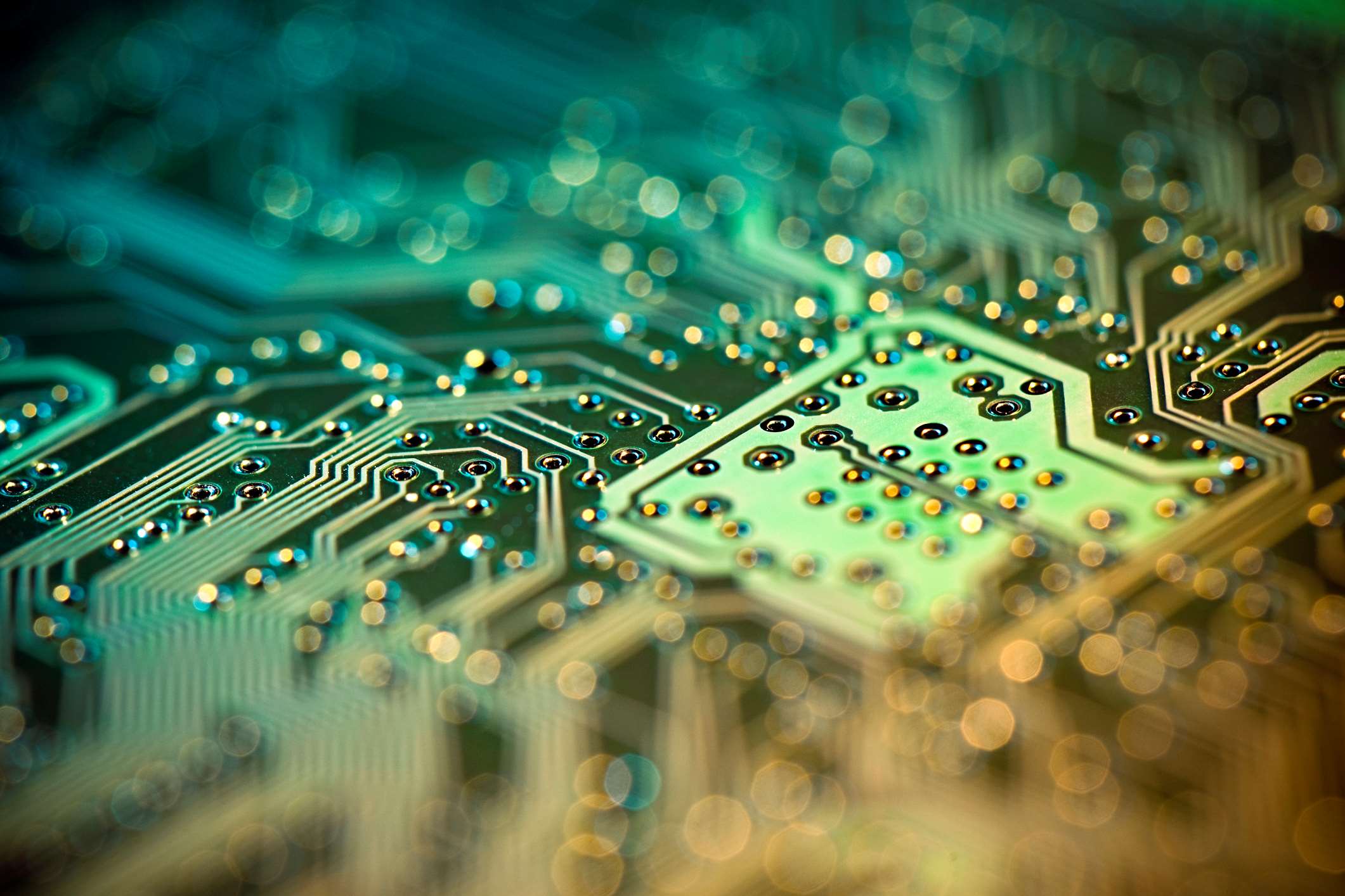 GaN Abstract close-up of a semiconductor circuit board with glowing traces and bokeh lights