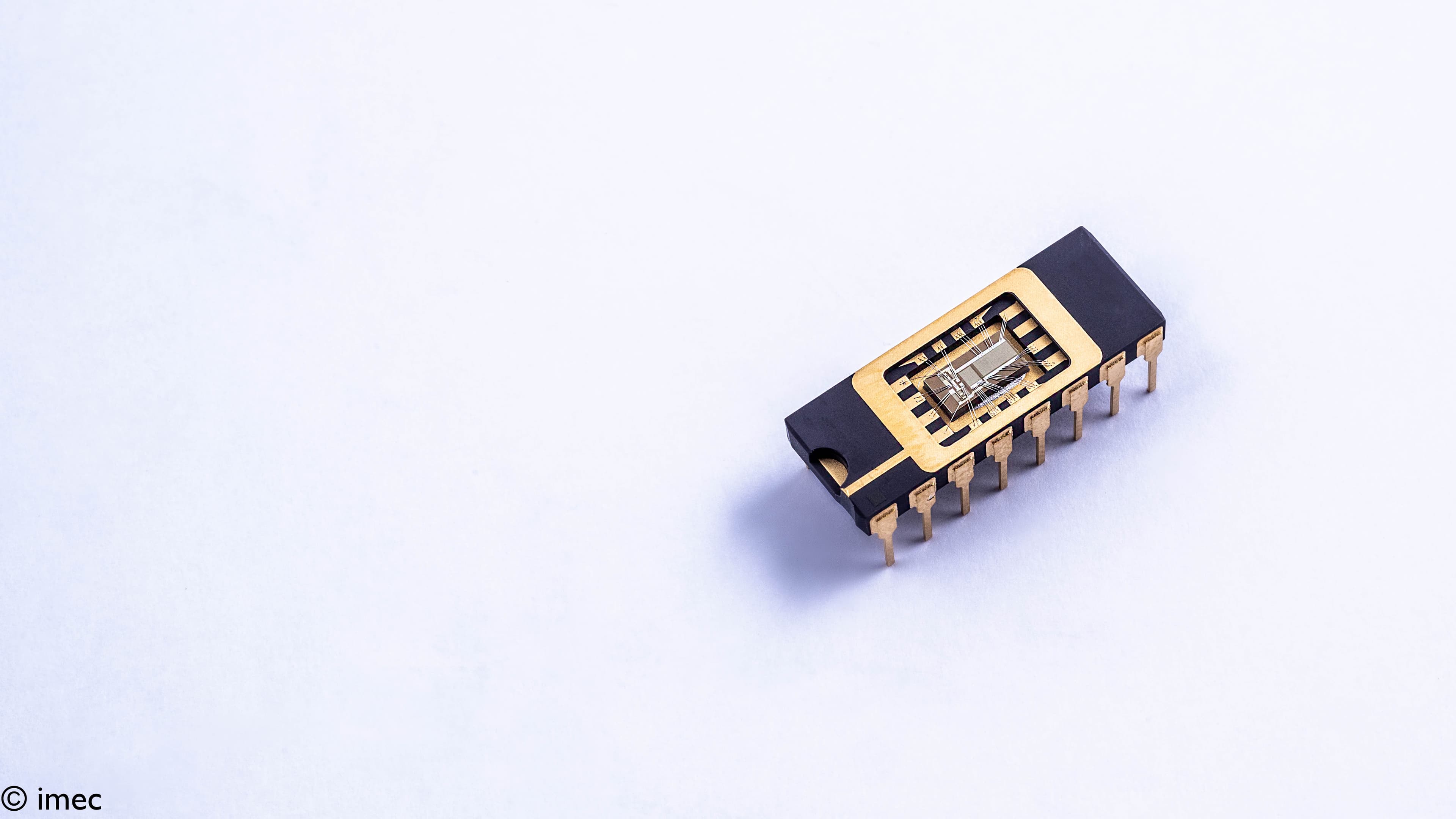 GaN integrated circuit package with exposed chip die GaN integrated circuit package with exposed chip die and gold pins on a white background