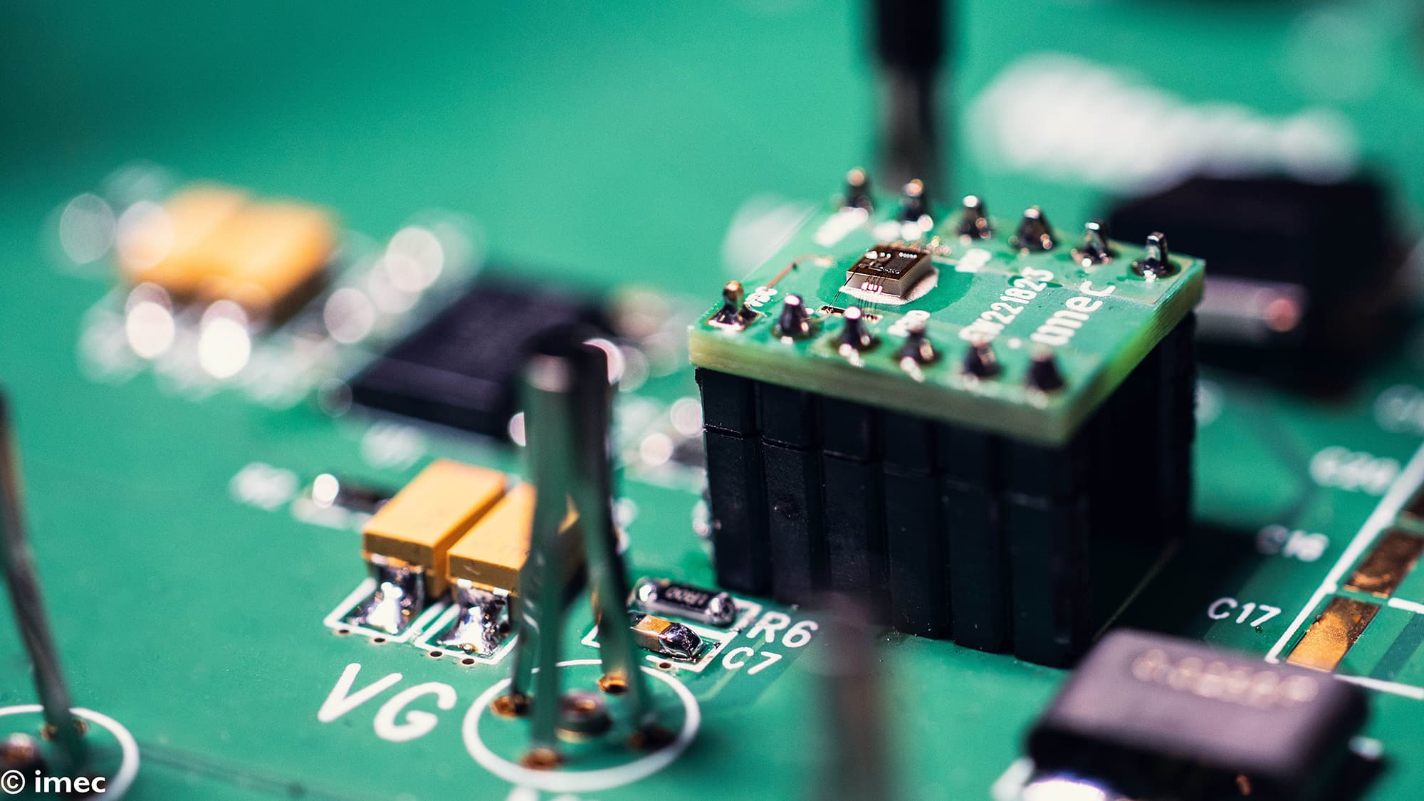 ganic007_1 Close-up of a green circuit board with a mounted chip and black power components.