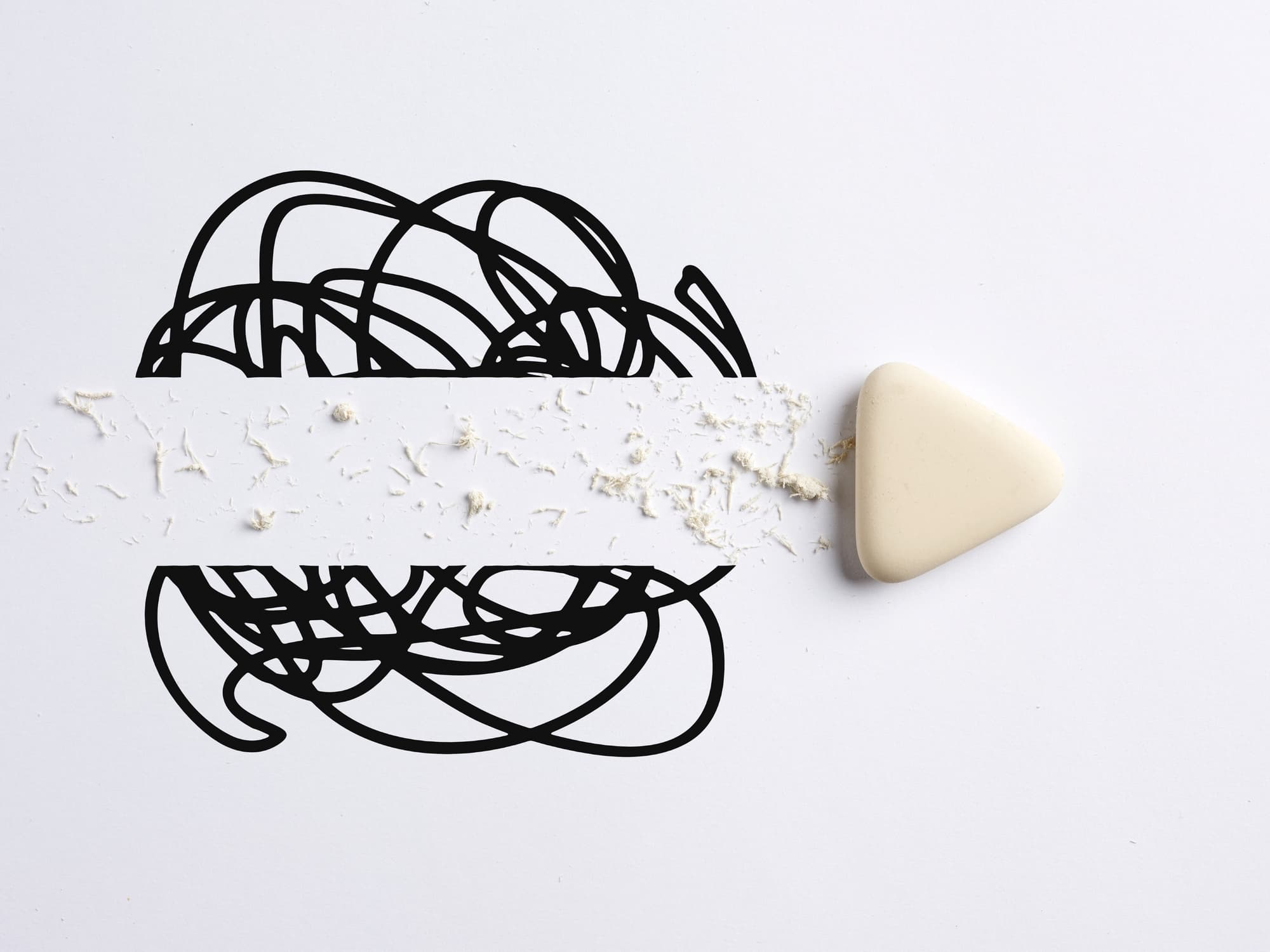 GettyImages-1473158597 Abstracte zwarte lijntekening met een beige driehoekige gum die een uitgesmeerde witte strook verwijdert
