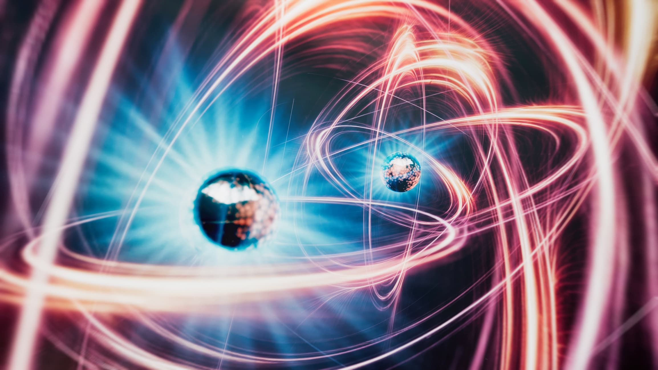 GettyImages-2151292914 Abstract quantum illustration with glowing light trails orbiting two spheres