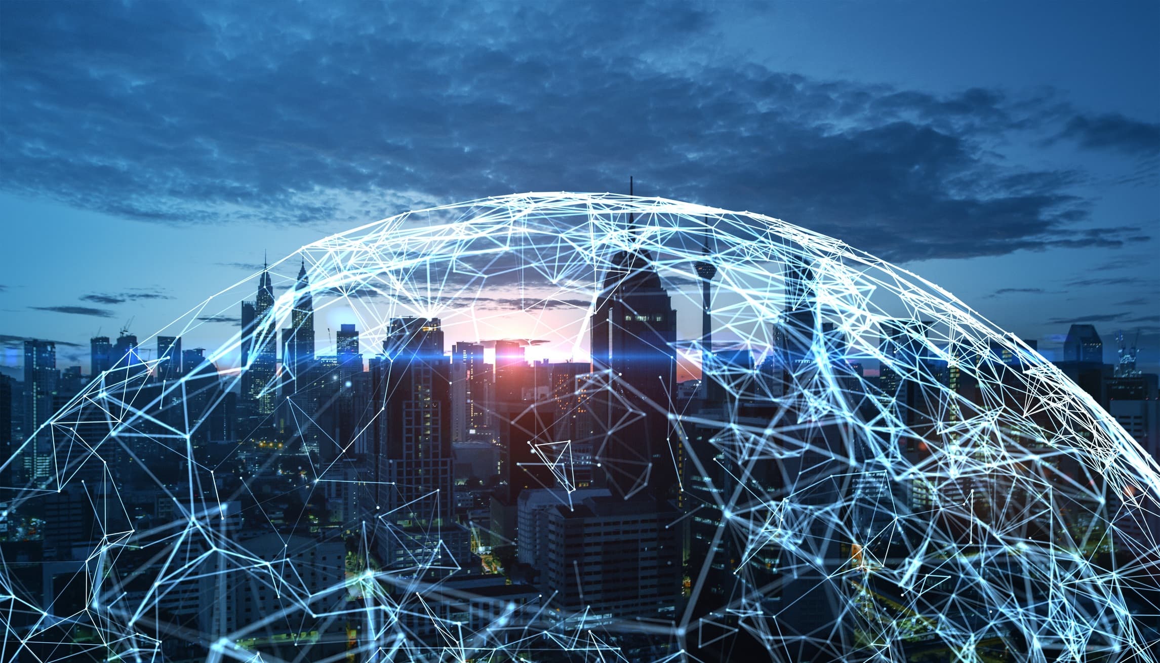 GettyImages-2186776849 City skyline at dusk overlaid with a glowing network globe