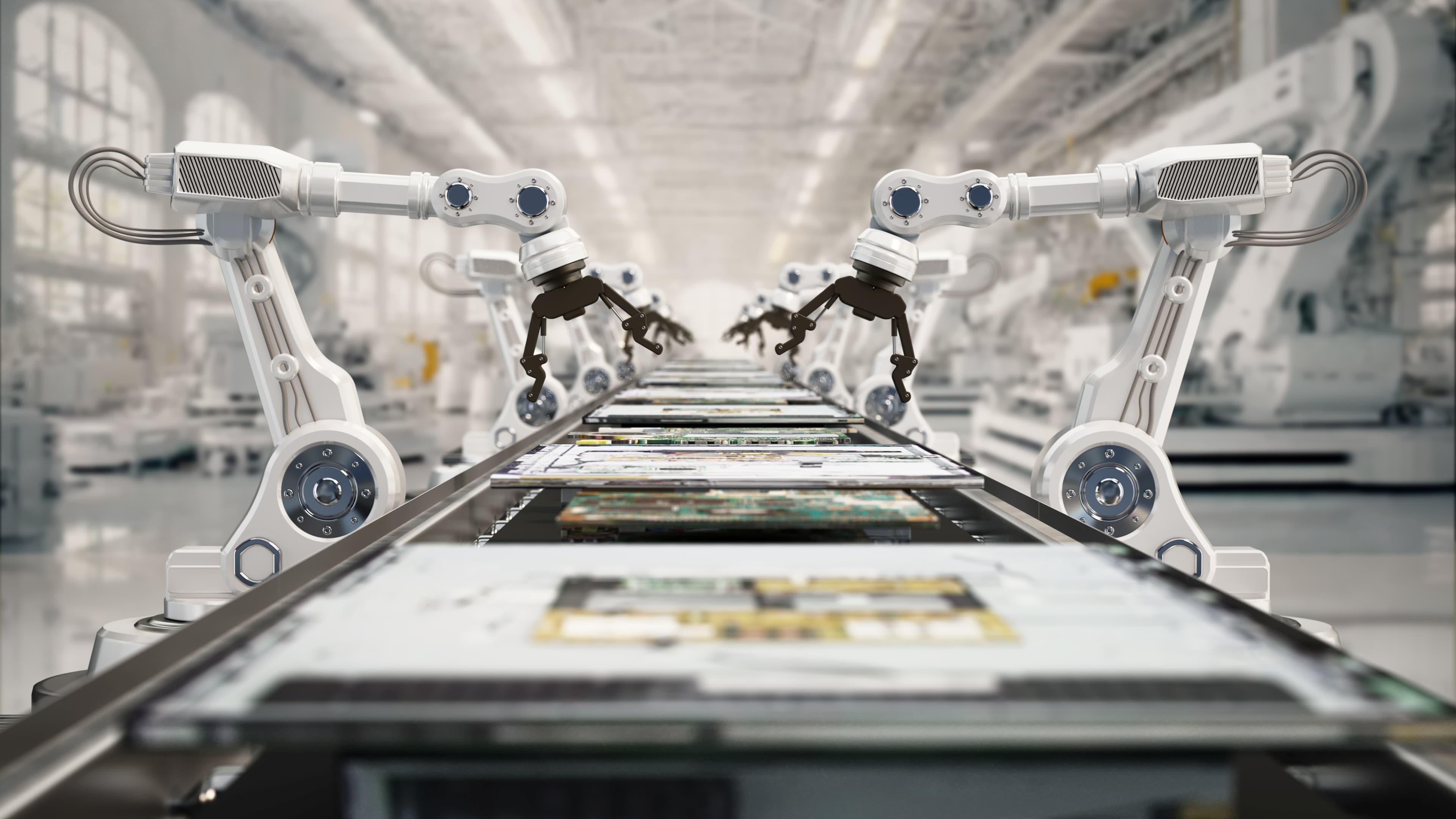 GettyImages-2210278635 Robotic arms handling circuit boards in a cleanroom-like factory line