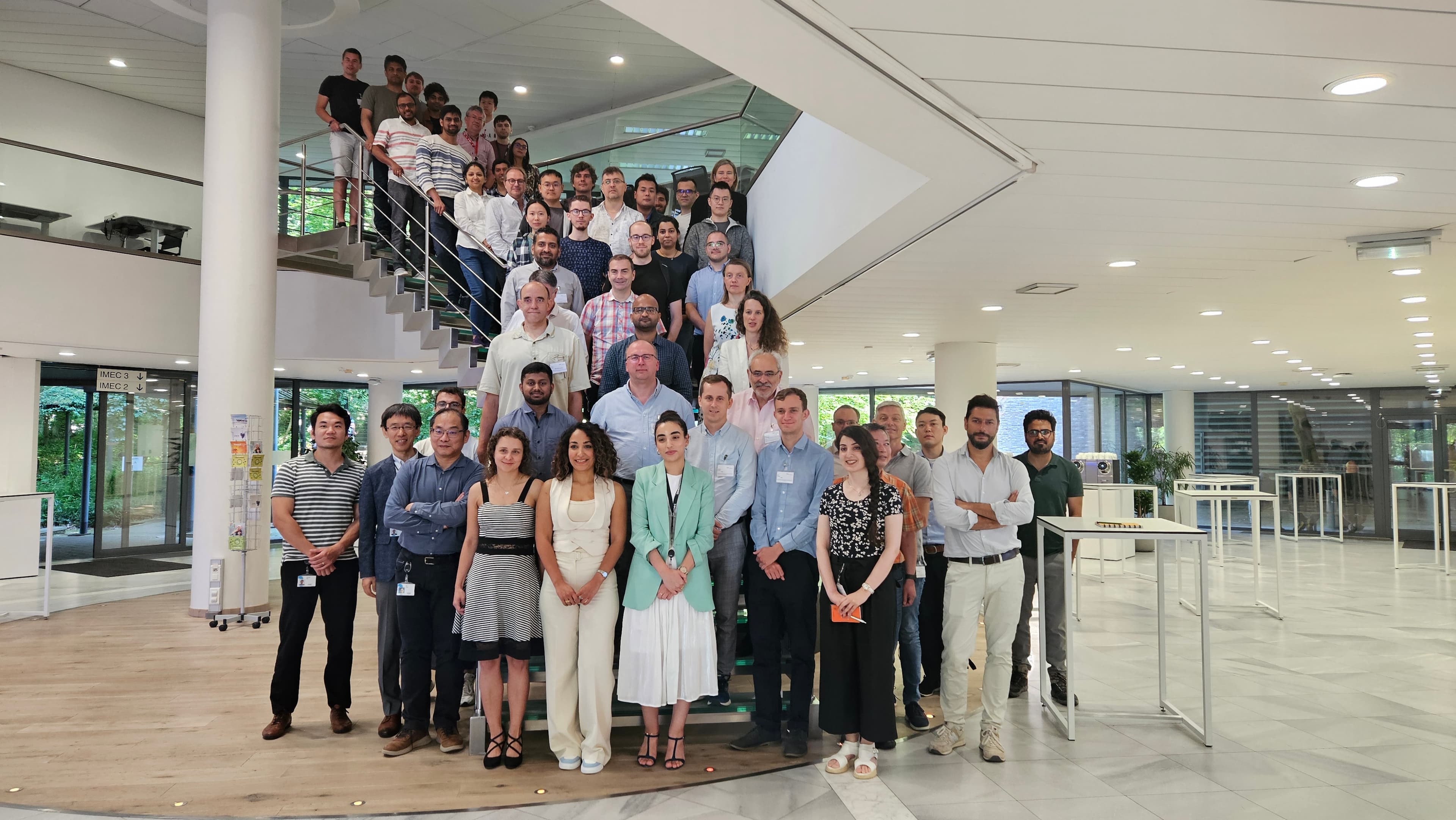 Group%20Picture Workshop participants posing on an indoor staircase in a bright atrium at imec