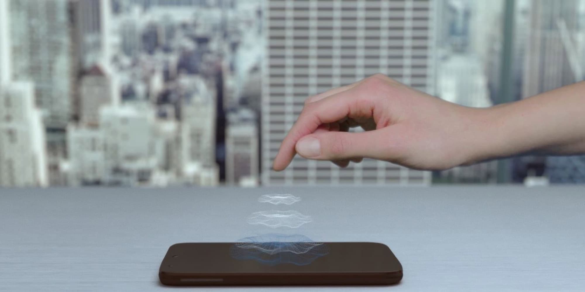 hapticfeedback_header Hand hovering above a smartphone with a projected haptic wave effect