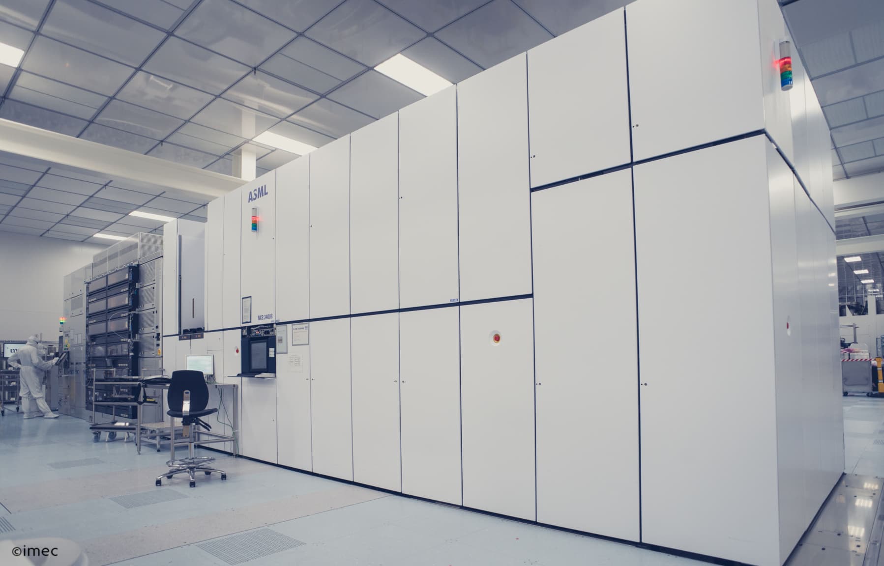 ASML lithography tool in cleanroom with technician Cleanroom with a large ASML lithography tool and a technician working beside it
