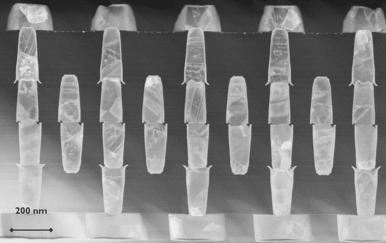 Header_0 Scanning electron microscope view of hybrid-bonded interconnects with a 200 nm scale bar