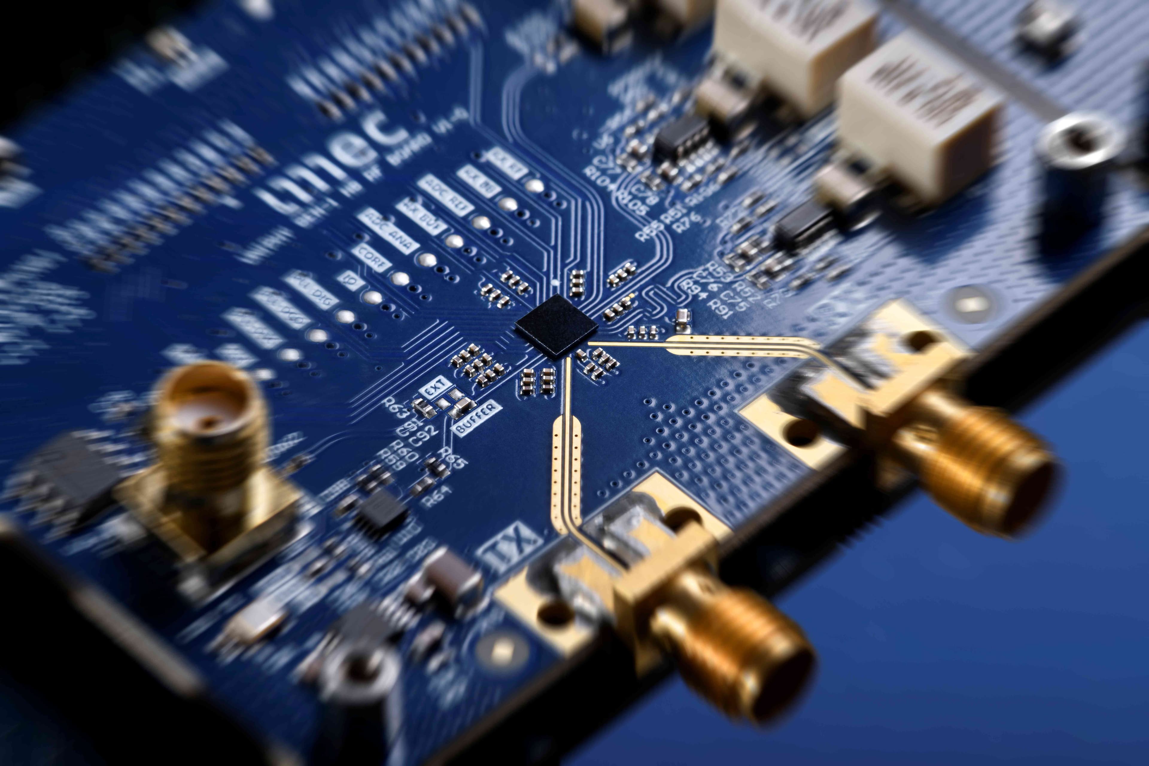 Close-up of blue circuit board with central chip and RF connectors Blue circuit board with a central chip and RF connectors, shown in close-up