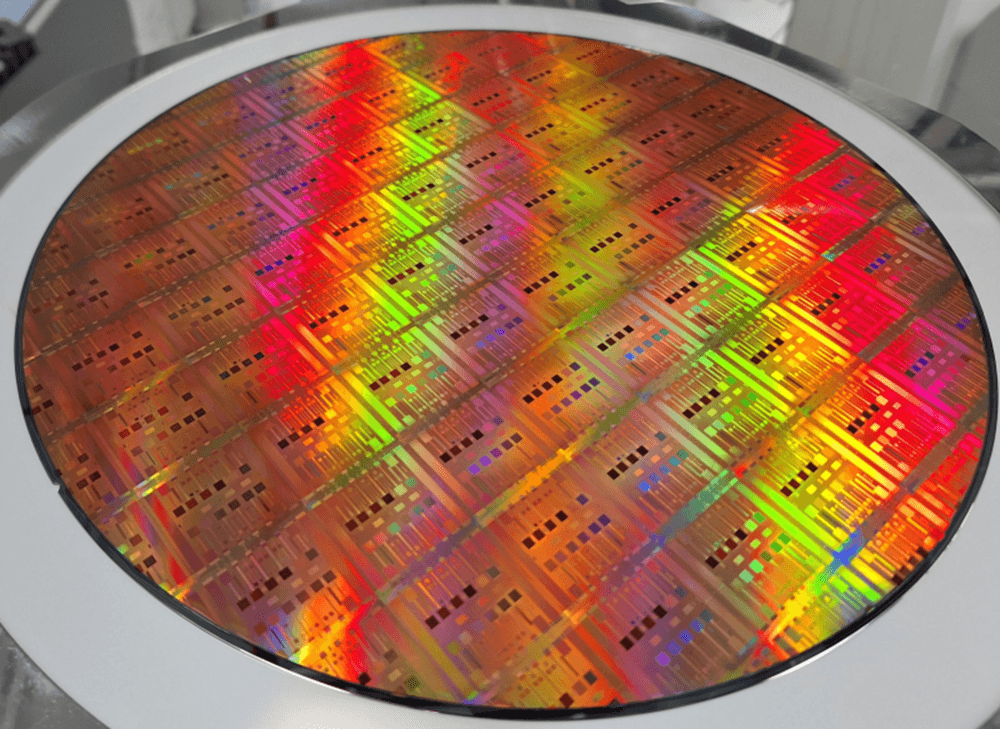 header%20Original_300%20mm%20wafer%20featuring%20imec%27s%20integration%20metasurfaces%20and%20quantum%20dot%20imagers Colorful 300mm semiconductor wafer with patterned chip dies