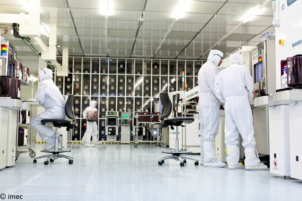 Researchers in cleanroom suits working in semiconductor lab Researchers in cleanroom suits working with semiconductor equipment in a laboratory
