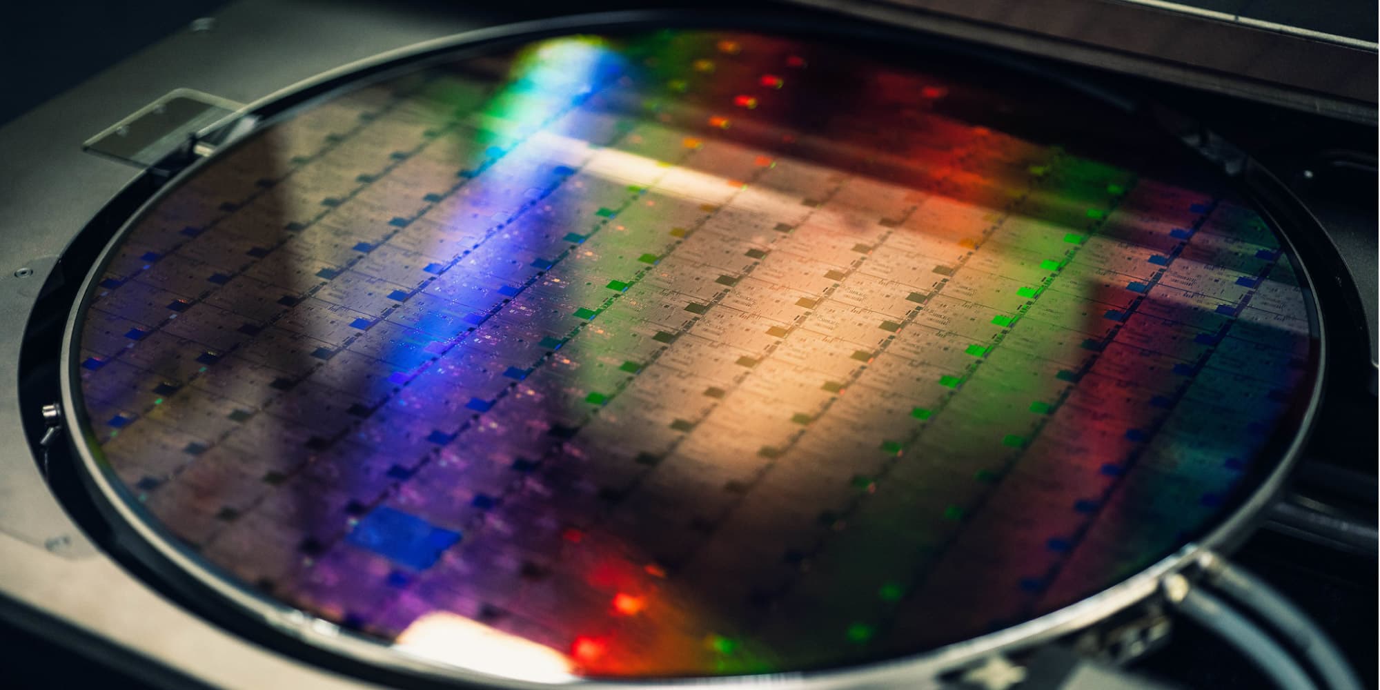 header-2D Silicon wafer with iridescent reflections under inspection, showing a patterned semiconductor surface