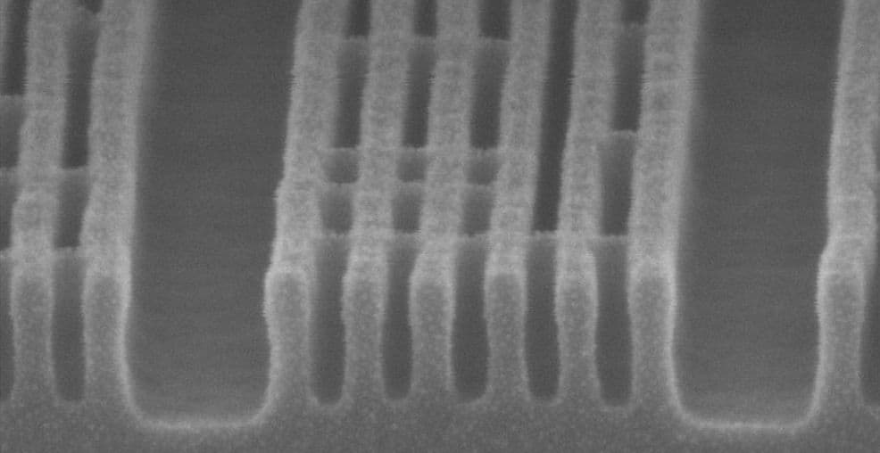 Header_-_metal2_layer_1 Microscope view of repeating nanoscale metal lines and gaps on a chip surface.