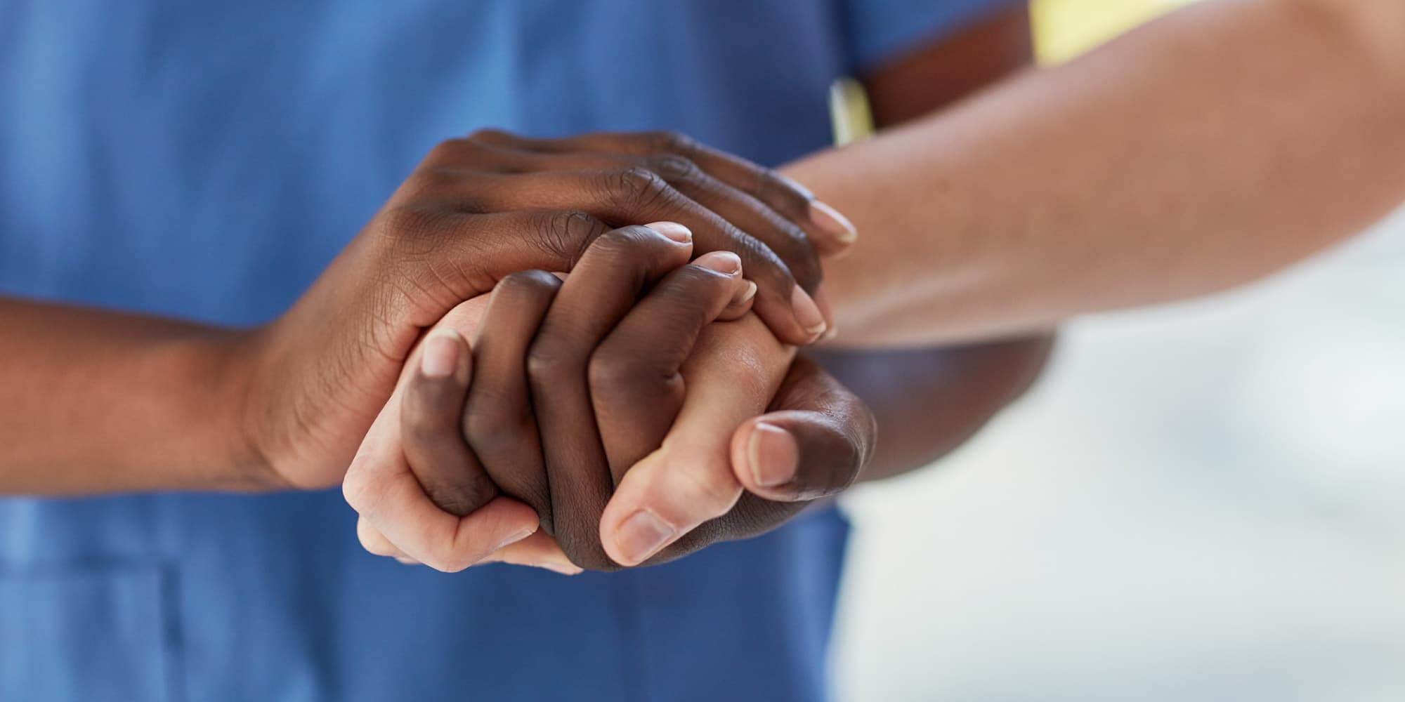 header_rarediseases Hands of two people clasped together in support