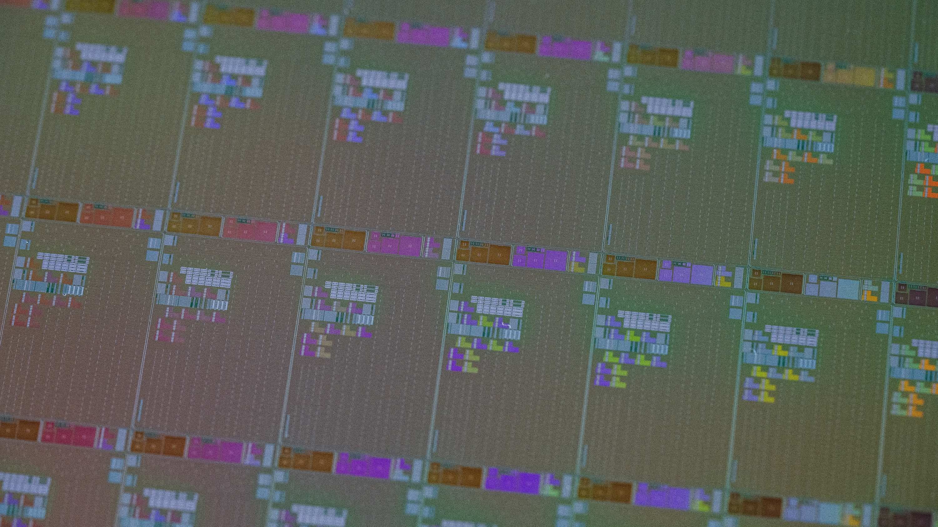 header_website Close-up of a semiconductor wafer with repeated chip layout patterns.