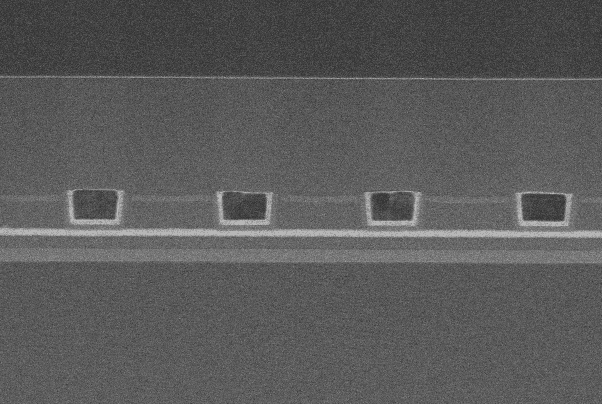 header2_3Dbuffermemory Cross-section of a semiconductor structure with four rectangular vias beneath layered films