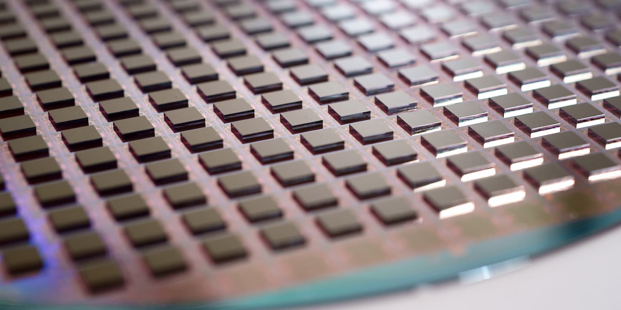 header3dstacking Close-up of a wafer covered with evenly spaced square semiconductor dies for packaging