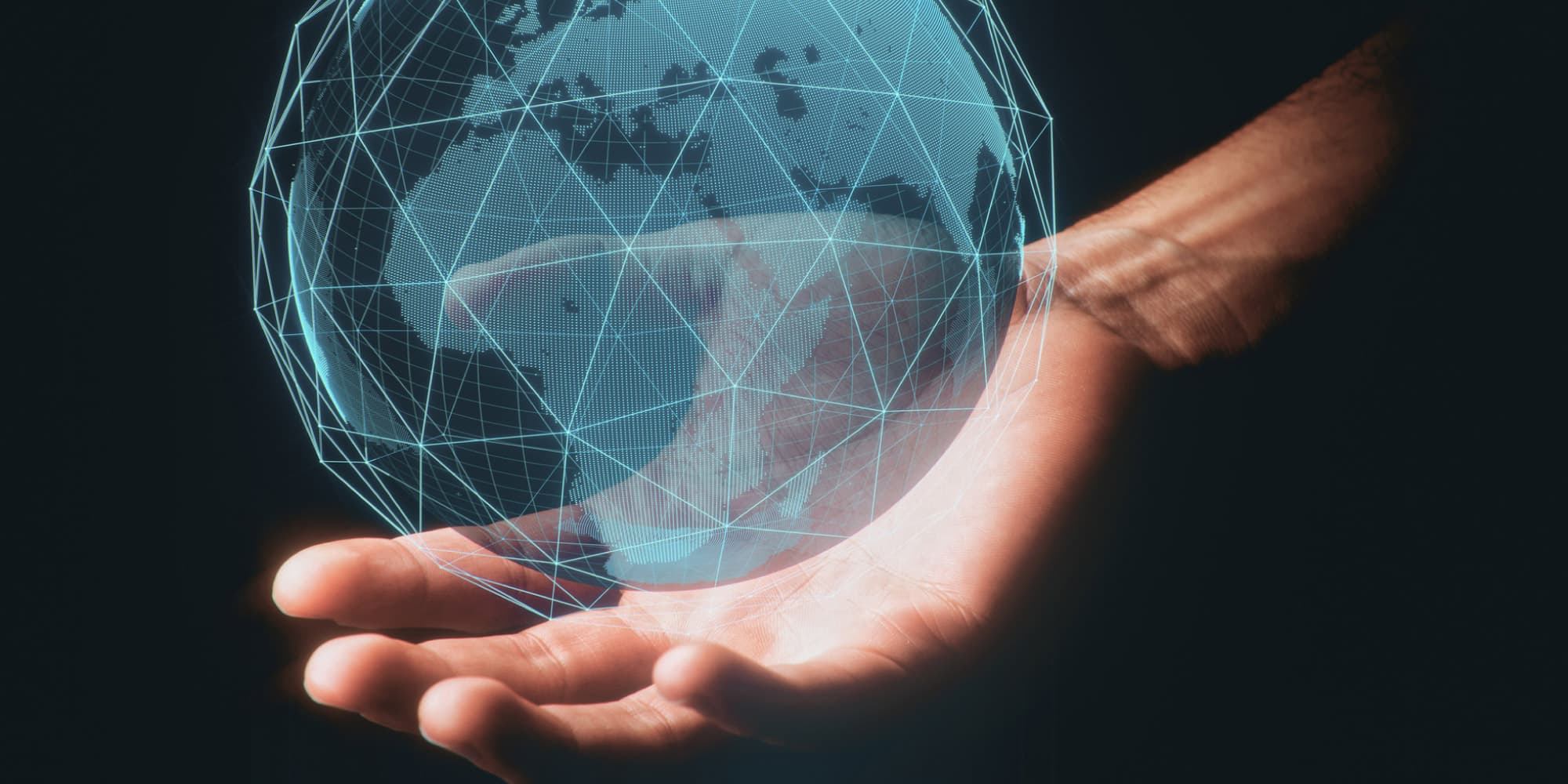 headerholografie A hand holds a glowing holographic globe made of blue wireframe lines and digital dots