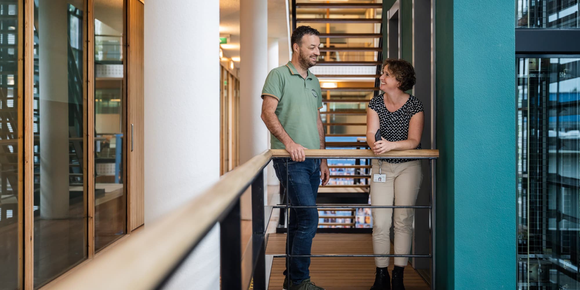 HolstCentre_3310-%281%29 Two colleagues talking on a balcony inside a modern office atrium