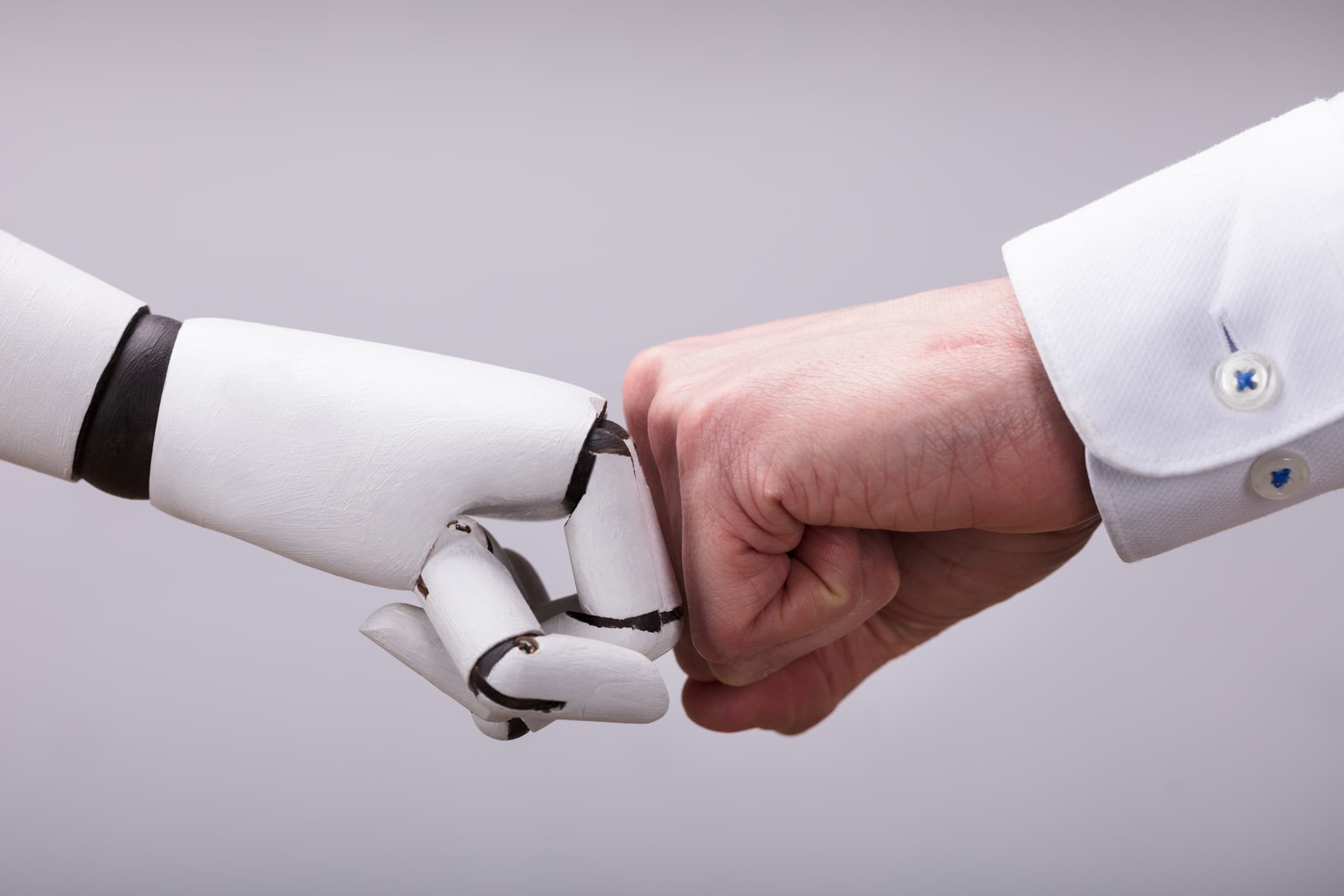 humanoid_robots_1 Human fist and robot hand touching knuckles in a fist bump