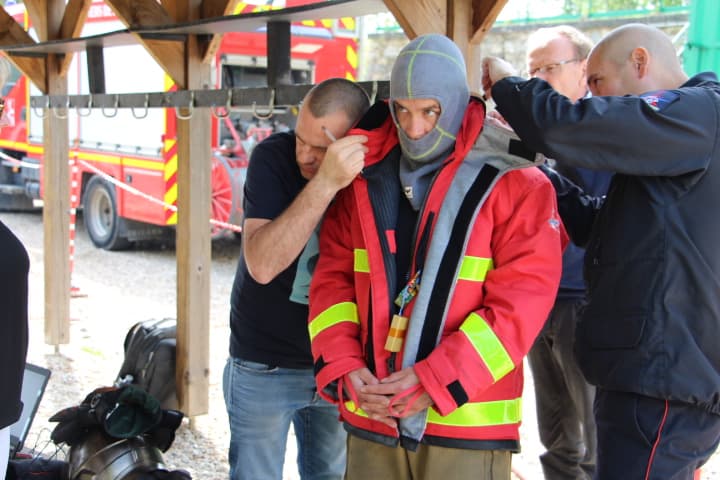 icart_brandweerpak_met_sensoren_7 Firefighter wearing a red protective suit with built-in sensors being adjusted by researchers