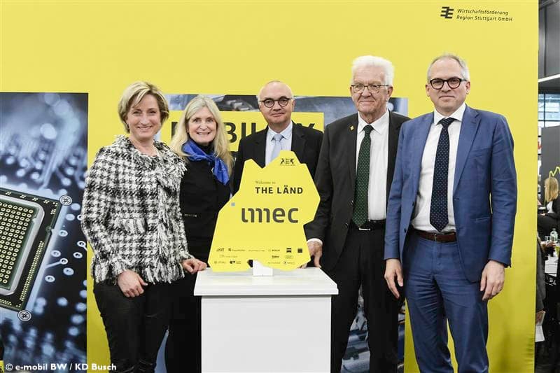 Five presenters at Baden-Württemberg imec event Five presenters stand beside a yellow imec sign at a Baden-Württemberg event backdrop.
