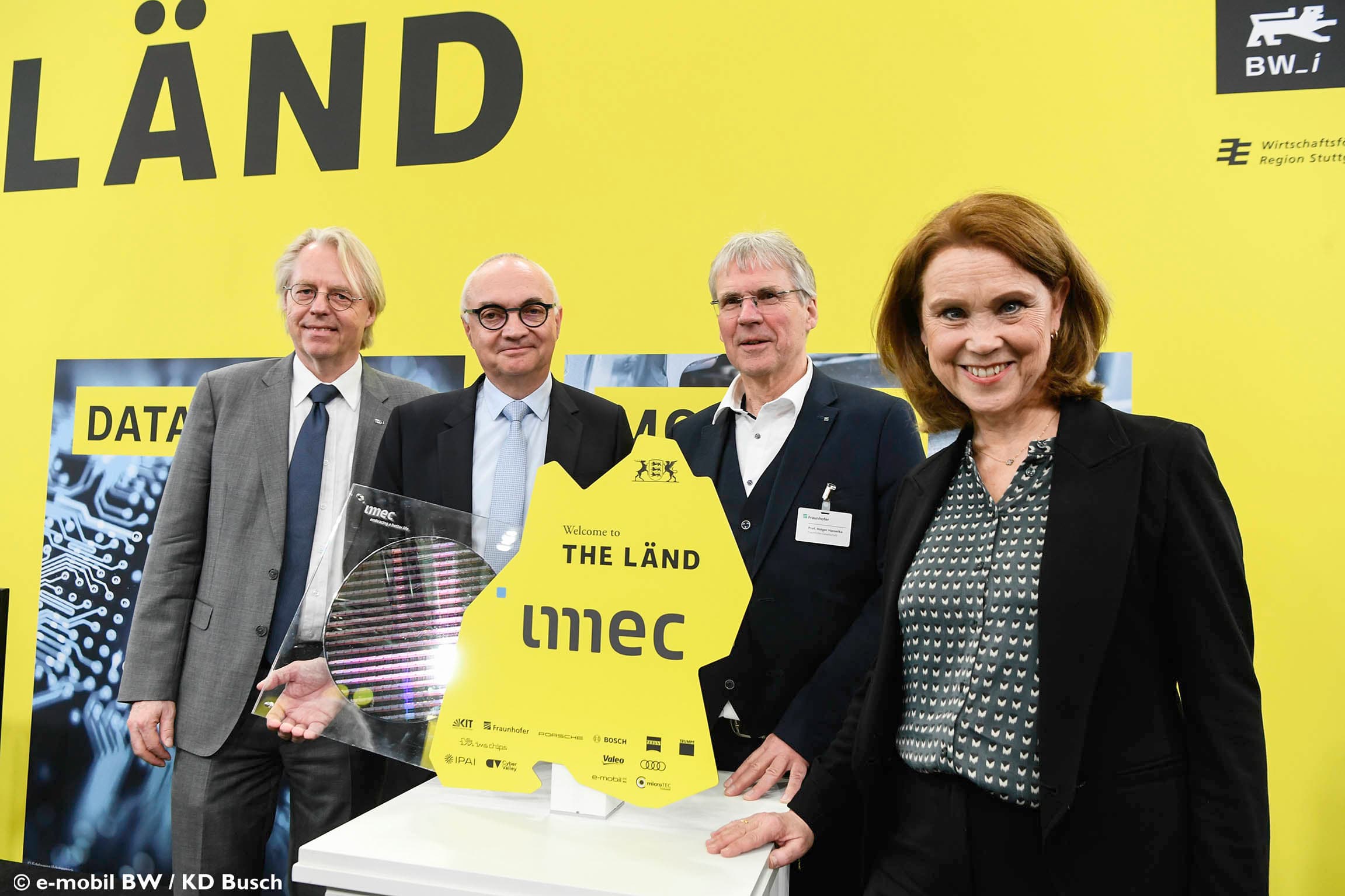 Four officials posing with imec display board at Baden-Württemberg event Vier officials poseren met een imec-displaybord op een evenement in Baden-Württemberg