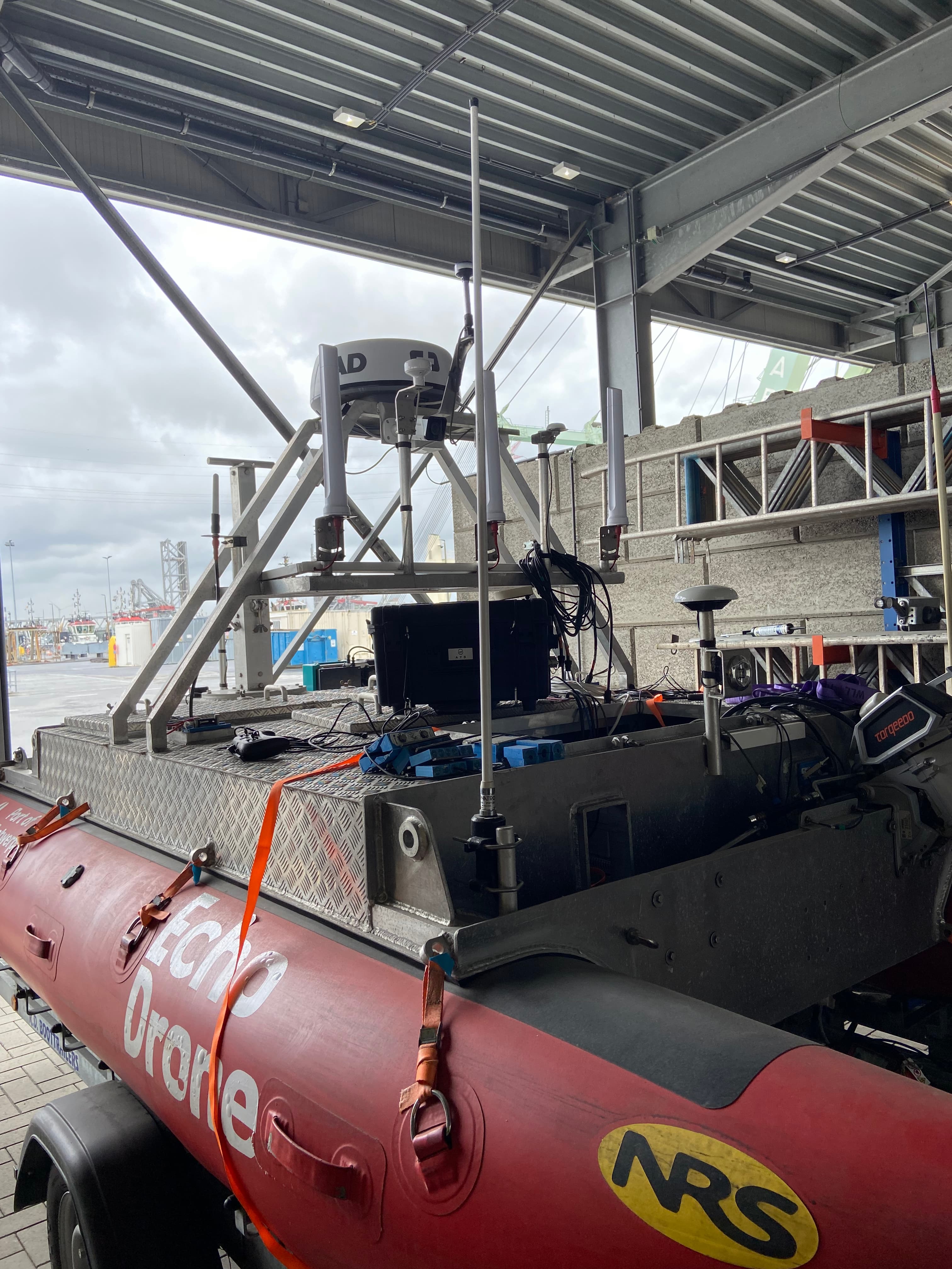 Image_ECHODRONE_0 Autonome onderzoeksboot met antennes en sensoren onder een havenshelter