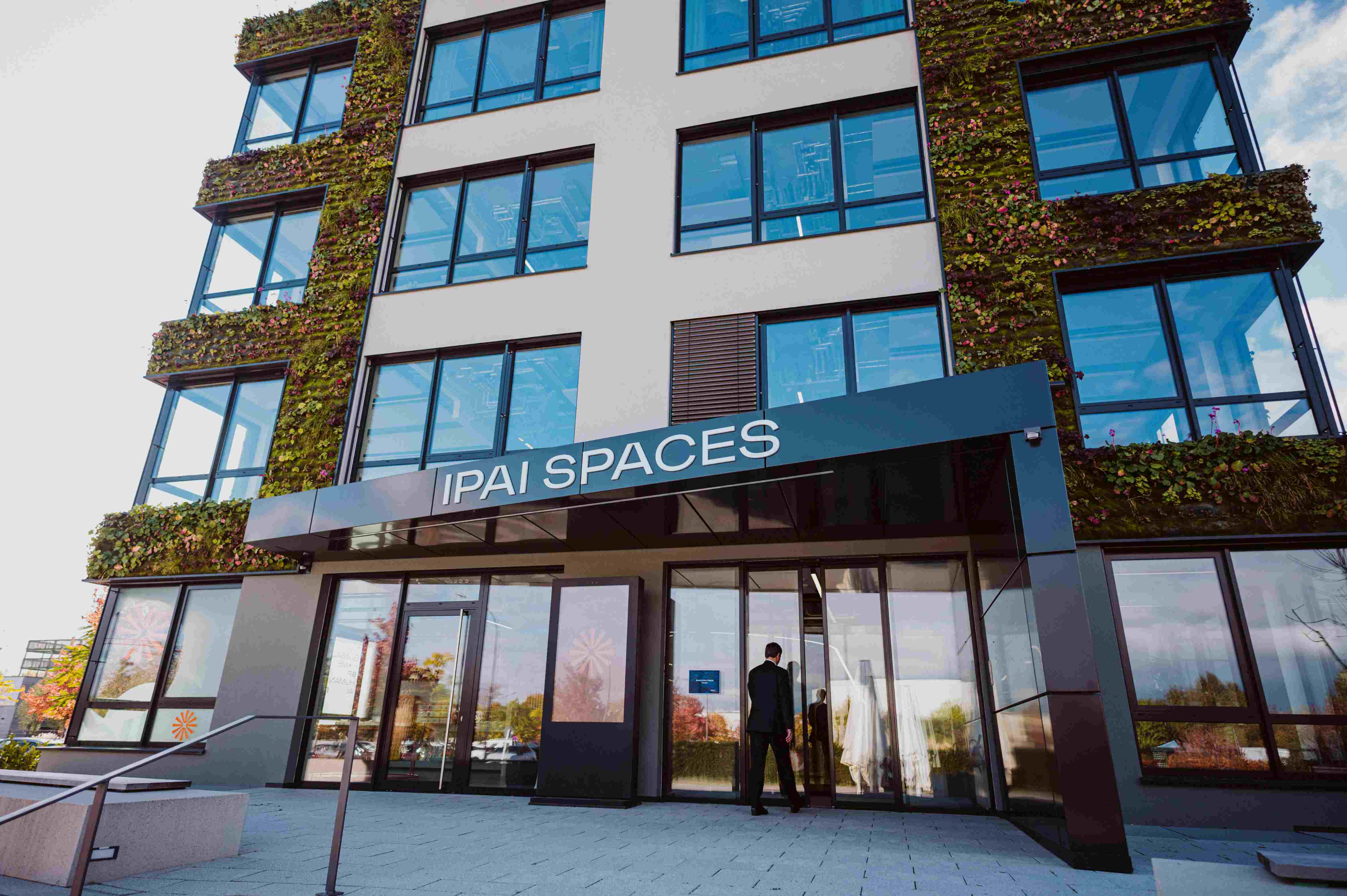 Imec%20ACF%20Fall_1 Modern glass-fronted building with an IPAI SPACES sign and vertical greenery on the facade