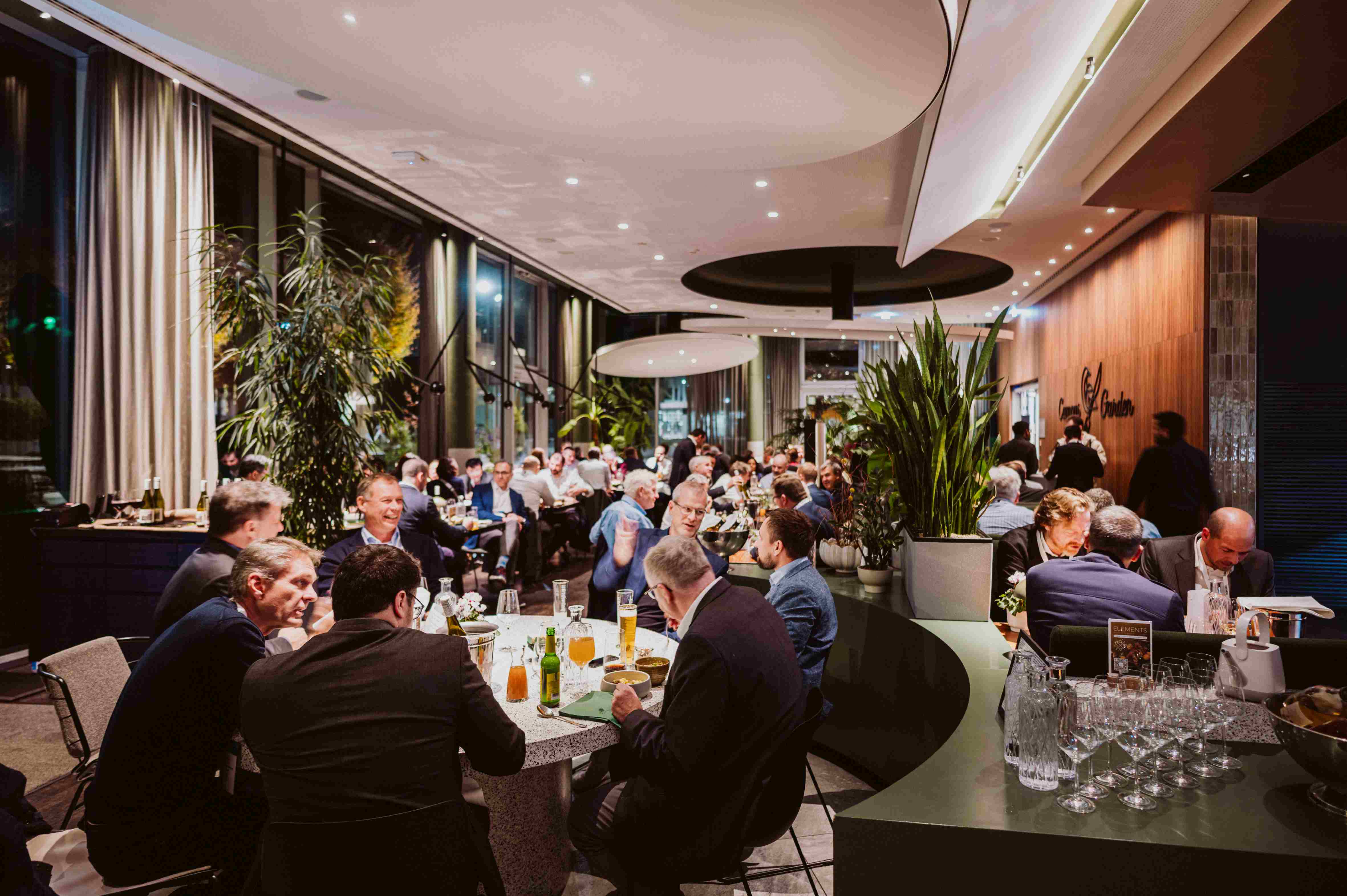 Imec%20ACF%20Fall_7 Conference dinner with attendees talking at round tables in a modern restaurant