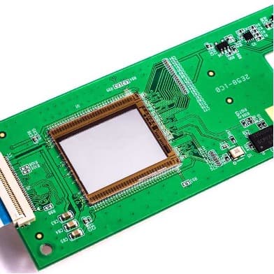 imec%20on-chip%20solution%20for%20raman%20spectroscopy Green circuit board with a central square chip package for on-chip Raman spectroscopy
